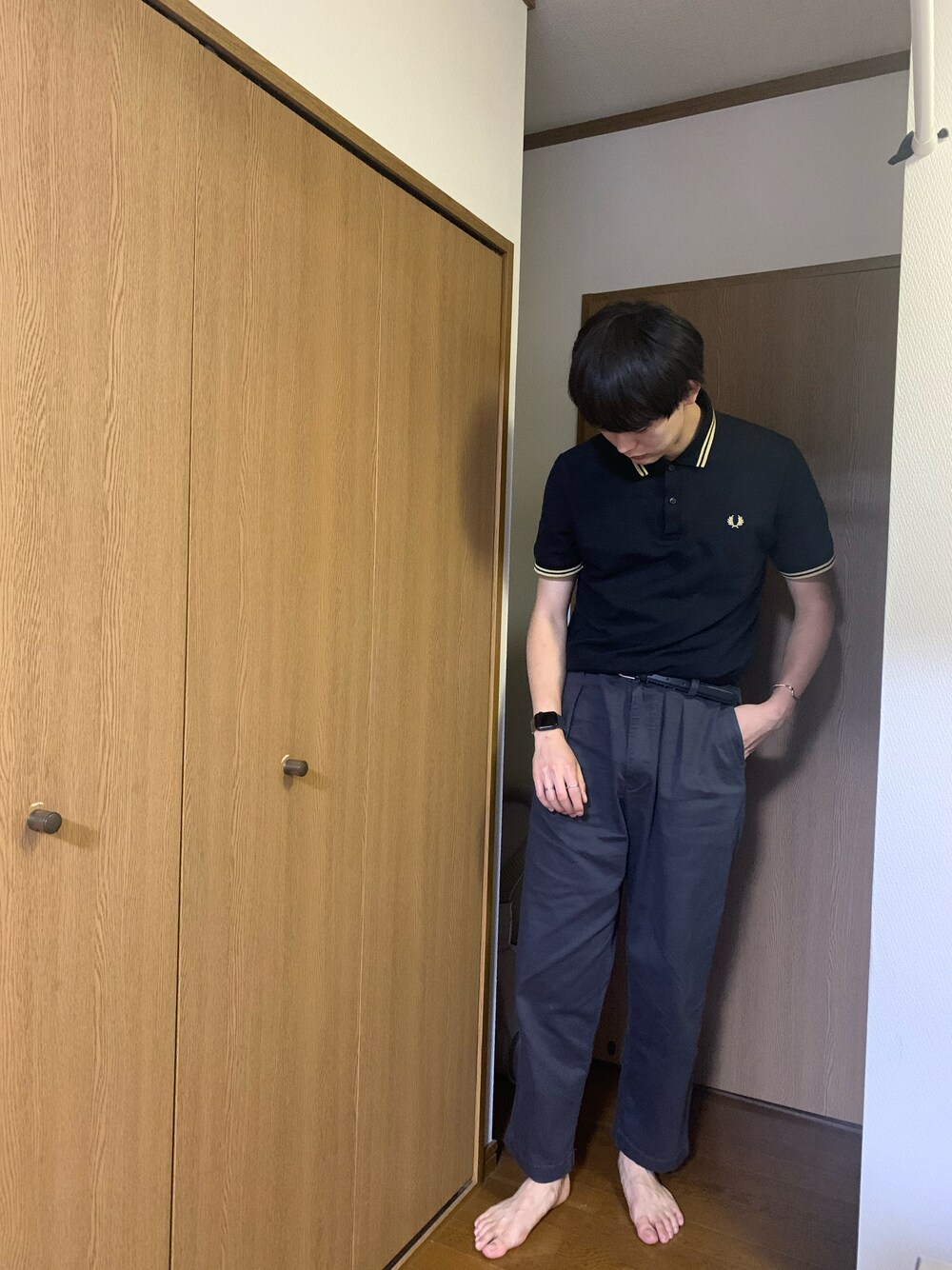 ブラック系のポロシャツ、グレー系のその他パンツ、ブラック系のスニーカーを着用したメンズの秋コーディネートの1枚目の写真