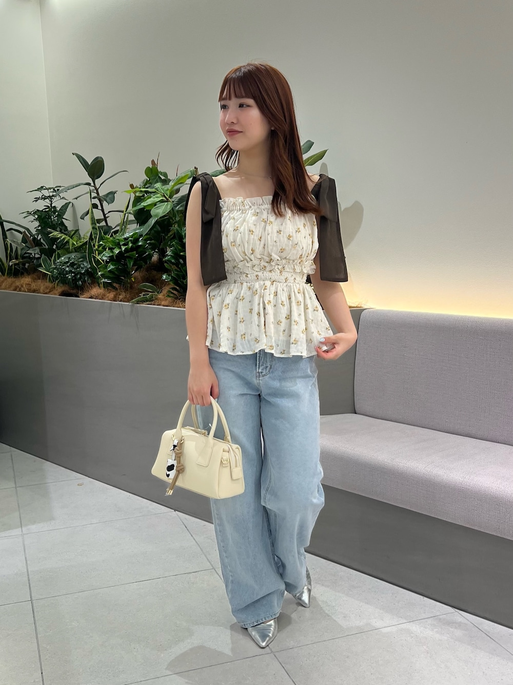 ベージュ系のシャツ/ブラウス、ブルー系のデニムパンツ、ブラウン系のボストンバッグを着用したレディースの夏コーディネートの1枚目の写真