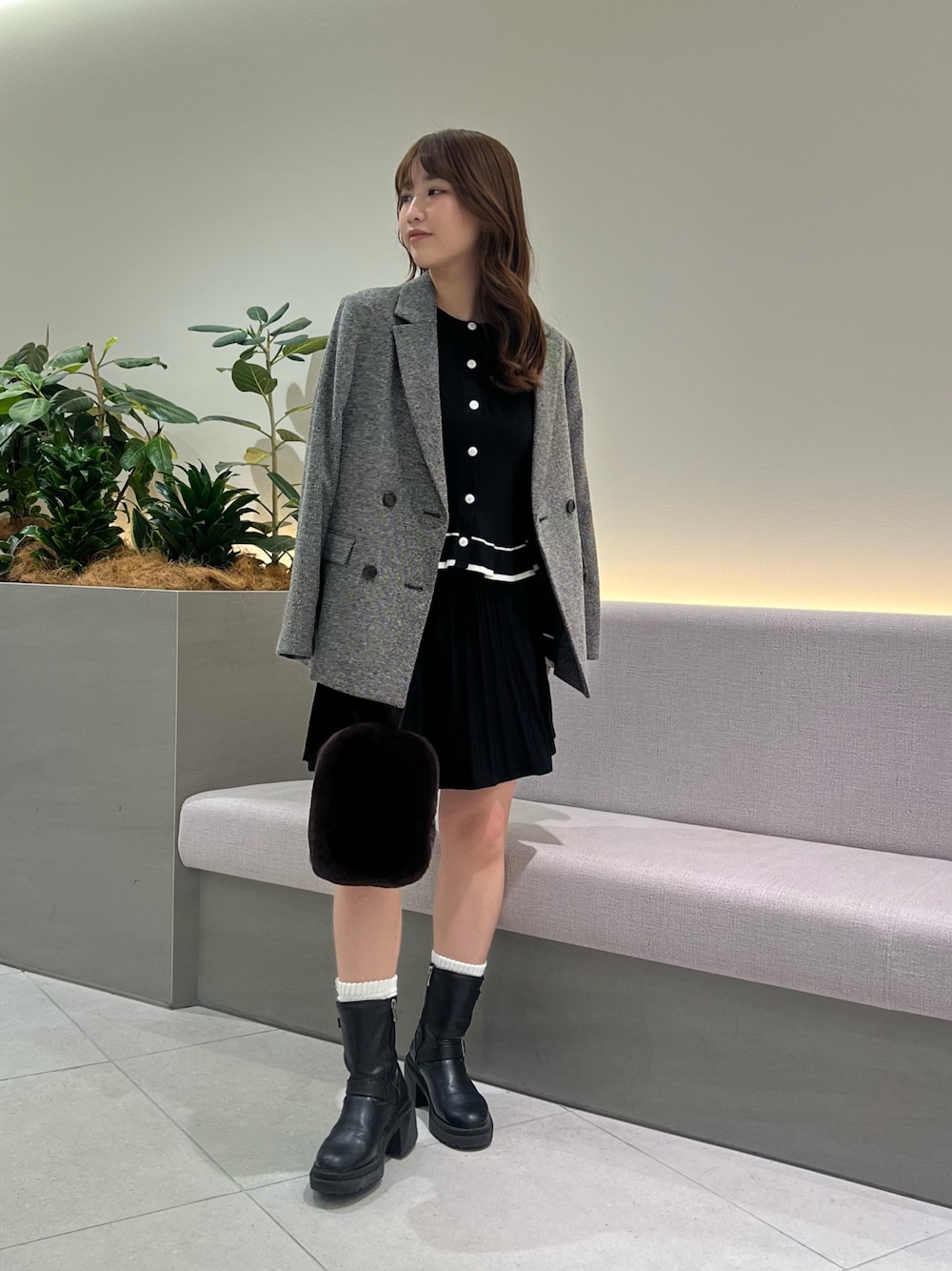 ブラック系のセットアップ、ブラック系のテーラードジャケット、ブラウン系のポーチを着用したレディースの秋コーディネートの1枚目の写真