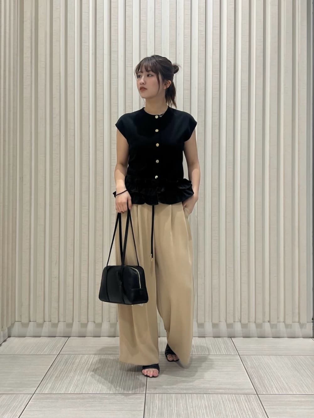 ブラック系のベスト、イエロー系のその他パンツ、ブラウン系のボストンバッグを着用したレディースの夏コーディネートの1枚目の写真