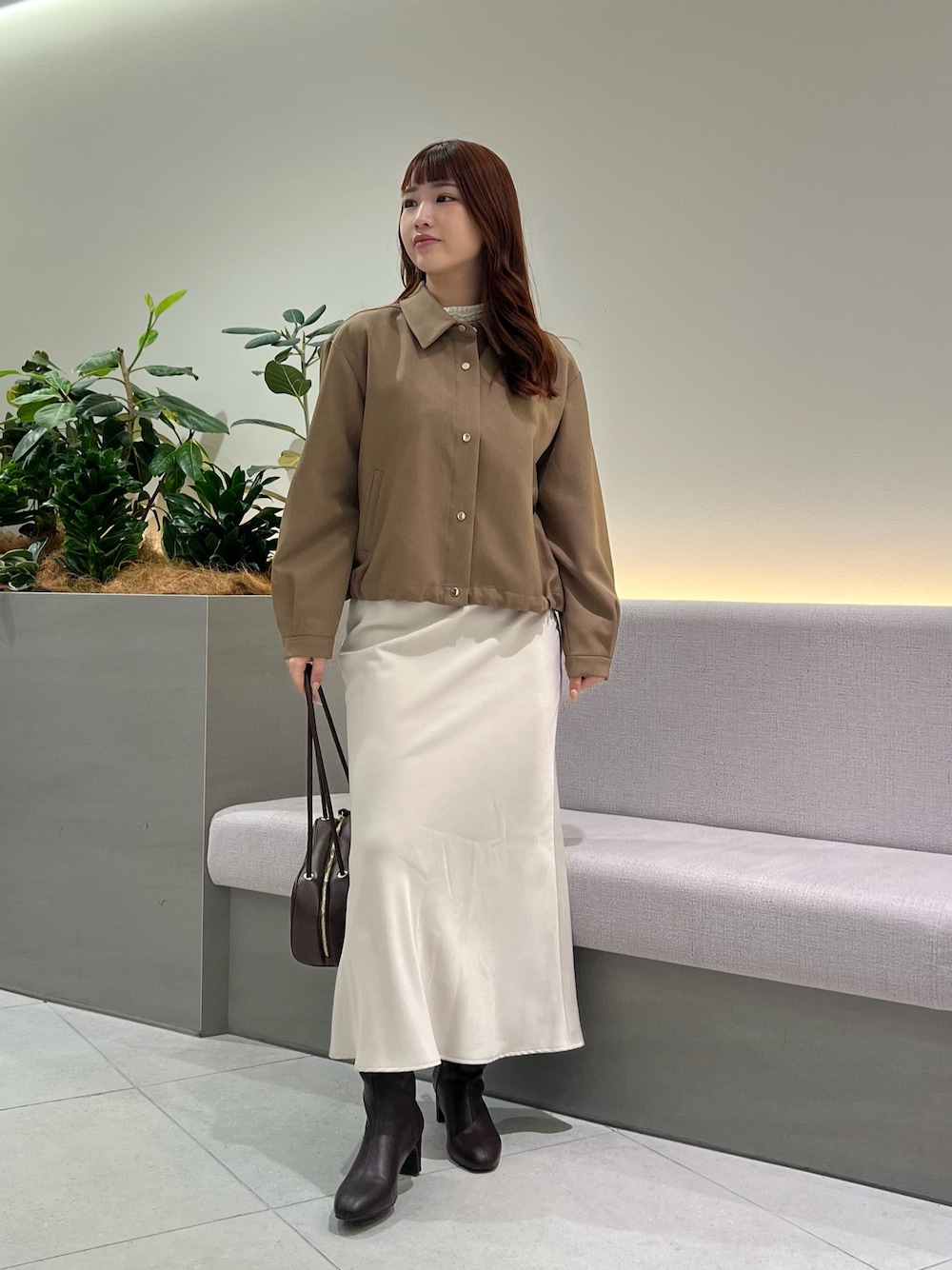 ブラウン系のブルゾン、ホワイト系のTシャツ/カットソー、ブラウン系のボストンバッグを着用したレディースの秋コーディネートの1枚目の写真
