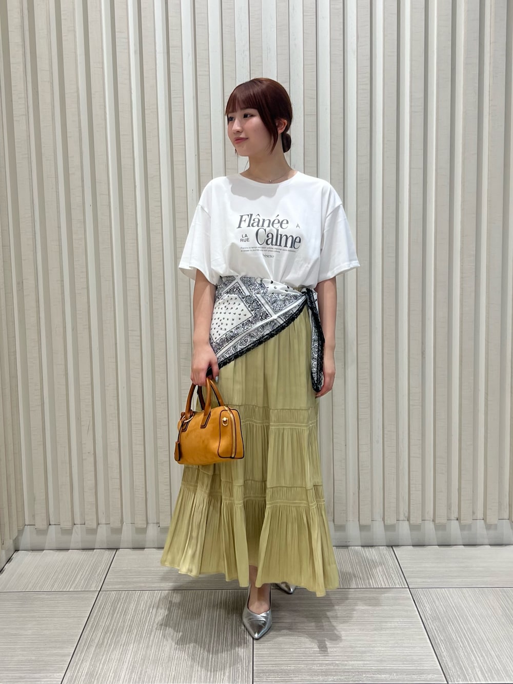 ホワイト系のTシャツ/カットソー、イエロー系のスカート、オレンジ系のボストンバッグを着用したレディースの夏コーディネートの1枚目の写真