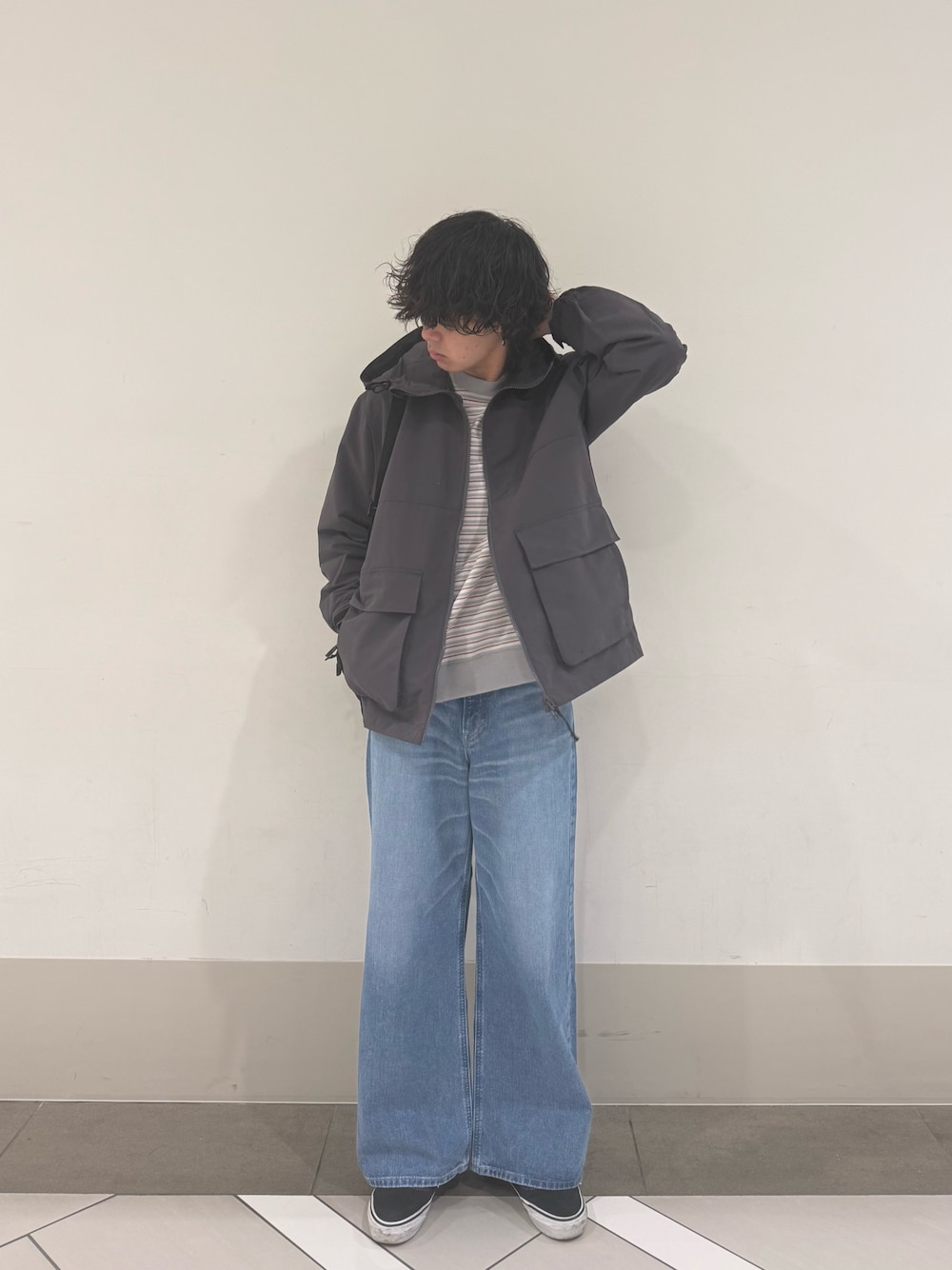 グレー系のマウンテンパーカー、ブルー系のデニムパンツを着用したメンズの冬コーディネートの1枚目の写真