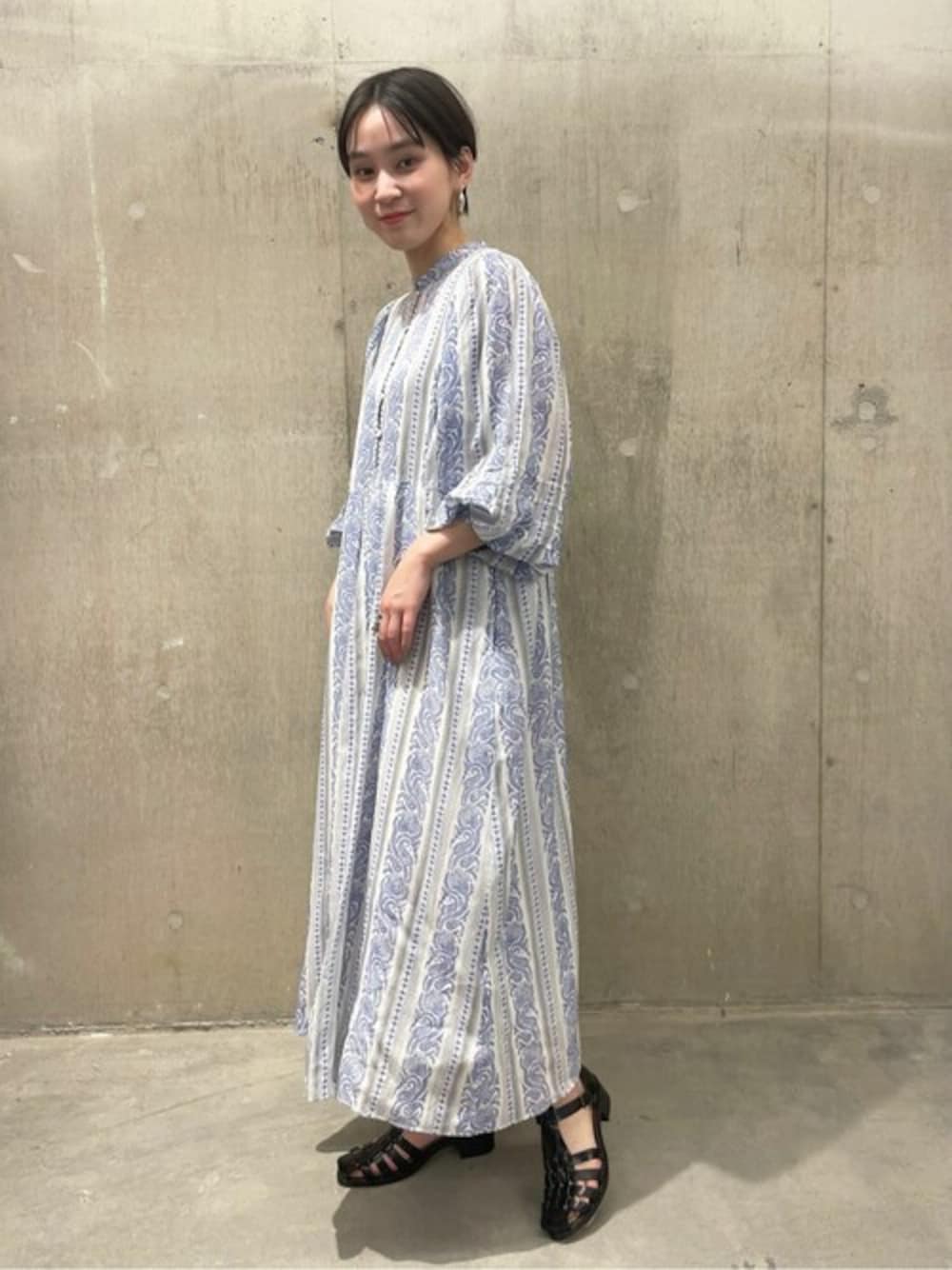 ホワイト系のワンピース、ホワイト系のショルダーバッグ、ブラック系のサンダルを着用したレディースの春コーディネートの1枚目の写真