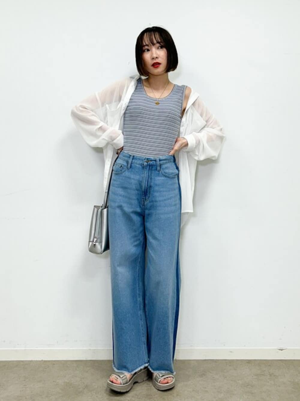 ホワイト系のシャツ/ブラウス、ブラック系のタンクトップ、ブルー系のデニムパンツを着用したレディースの春コーディネートの1枚目の写真