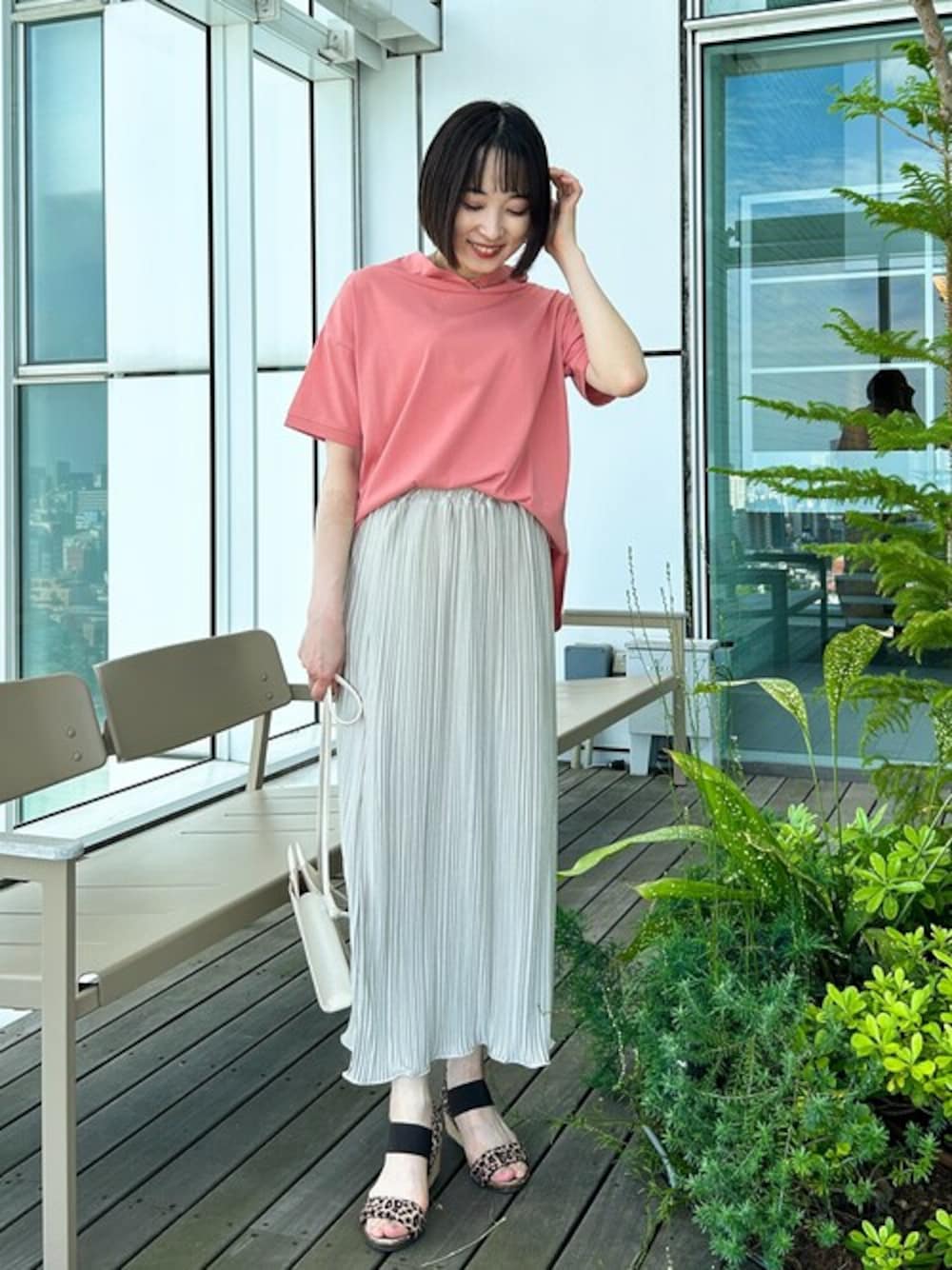 ピンク系のTシャツ/カットソー、ベージュ系のスカート、ブラウン系のサンダルを着用したレディースの春コーディネートの1枚目の写真