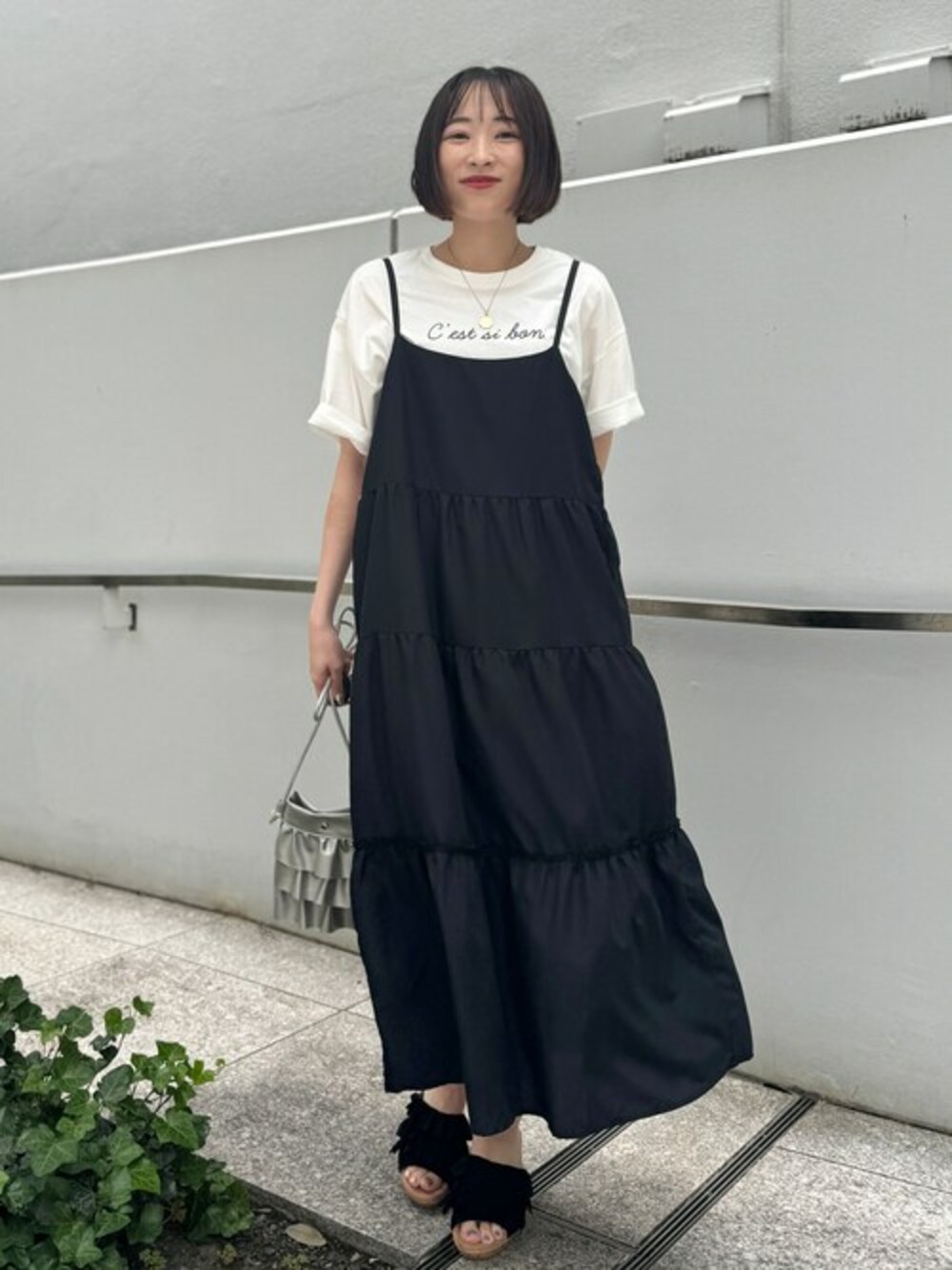 ブラック系のワンピース、シルバー系のショルダーバッグ、ブラック系のサンダルを着用したレディースの夏コーディネートの1枚目の写真
