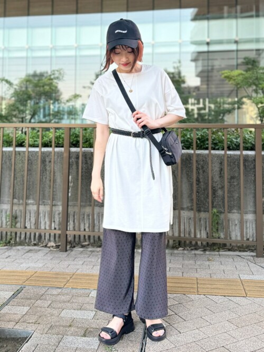 ホワイト系のチュニック、グレー系のその他パンツ、ブラック系のサンダルを着用したレディースの夏コーディネートの1枚目の写真