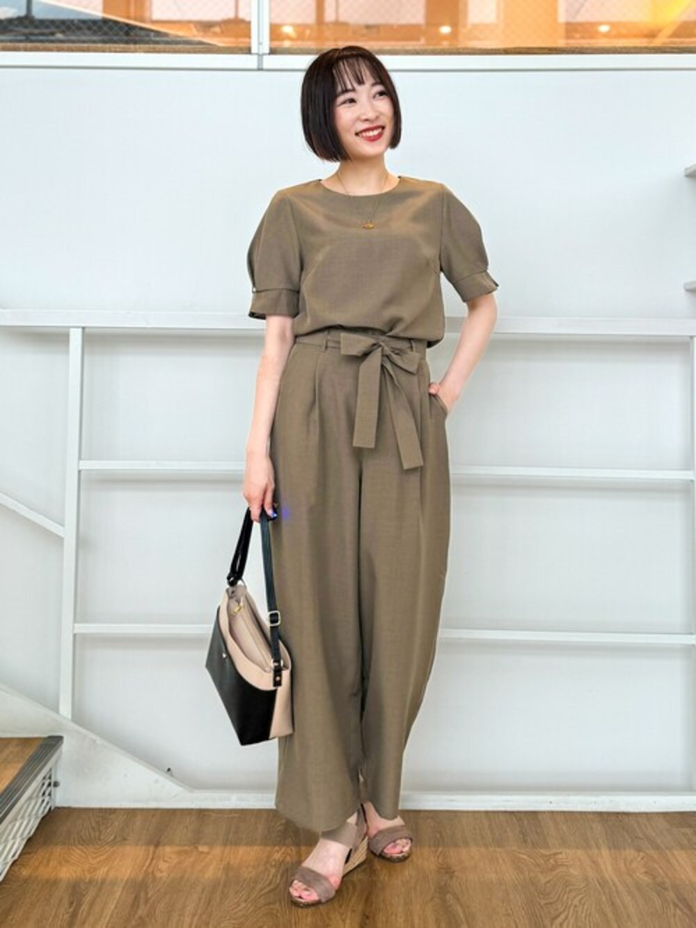 グリーン系のシャツ/ブラウス、グリーン系のその他パンツ、ベージュ系のショルダーバッグを着用したレディースの夏コーディネートの1枚目の写真