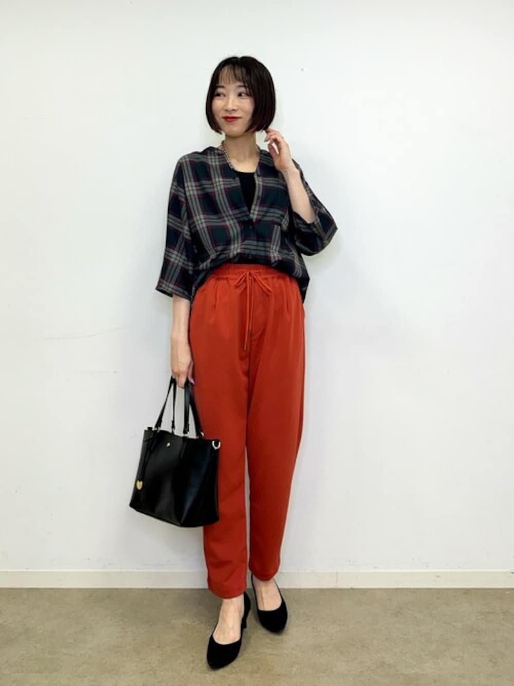 ブラック系のシャツ/ブラウス、ブラック系のタンクトップ、オレンジ系のその他パンツを着用したレディースの秋コーディネートの1枚目の写真