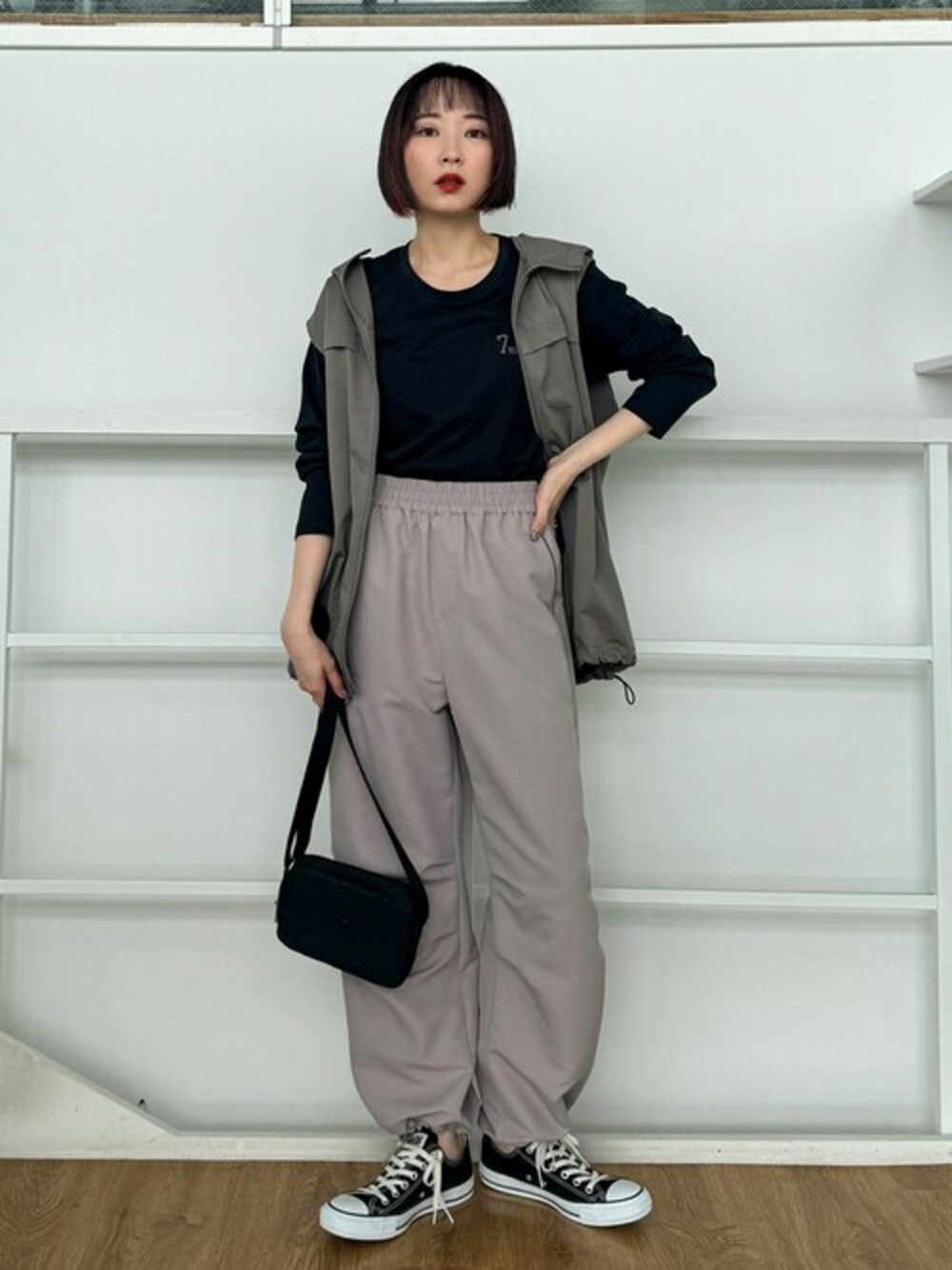 グリーン系のベスト、ベージュ系のその他パンツ、ブラック系のショルダーバッグを着用したレディースの秋コーディネートの1枚目の写真