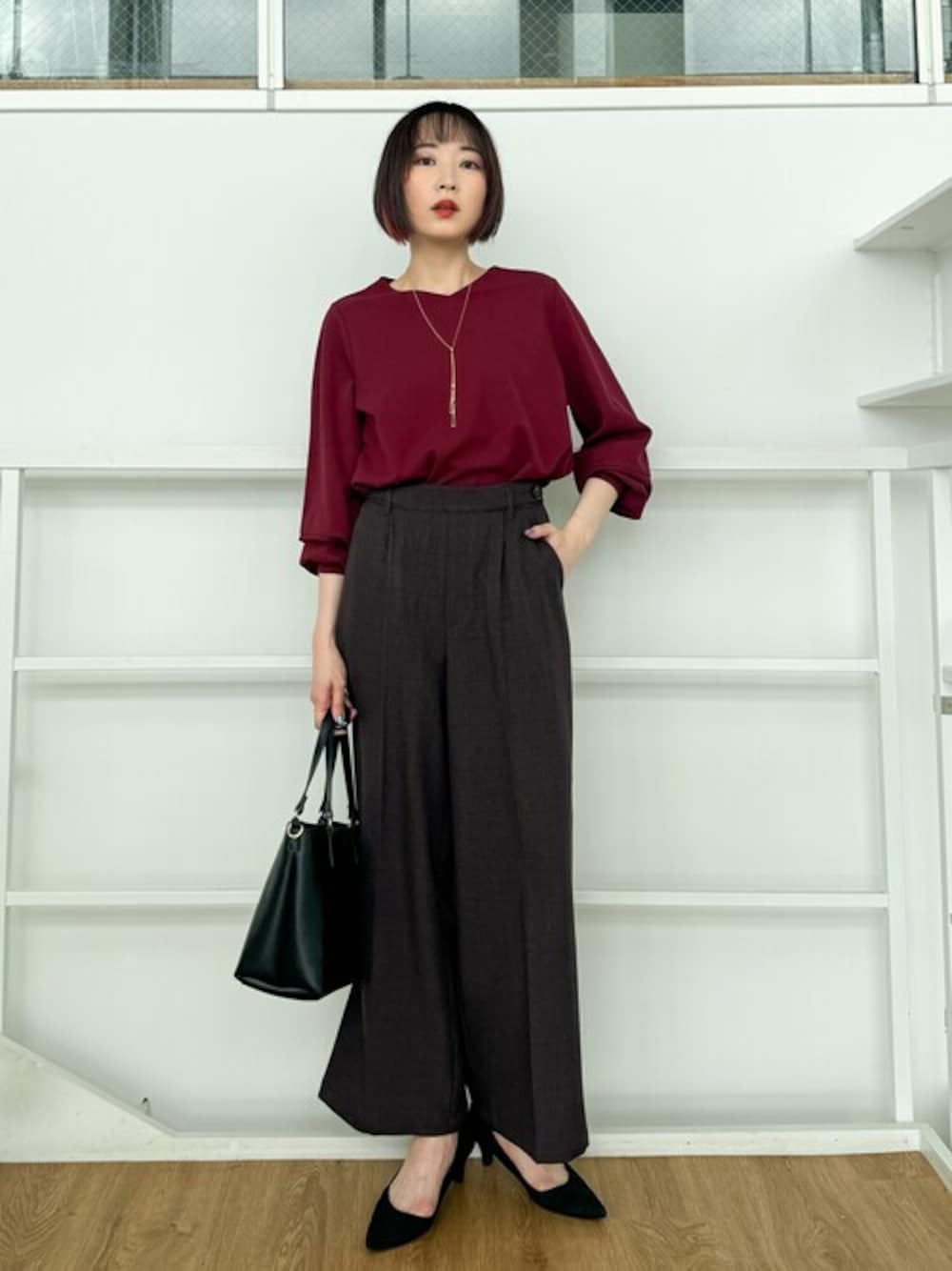 レッド系のシャツ/ブラウス、ブラック系のパンプス、ブラック系のトートバッグを着用したレディースの秋コーディネートの1枚目の写真