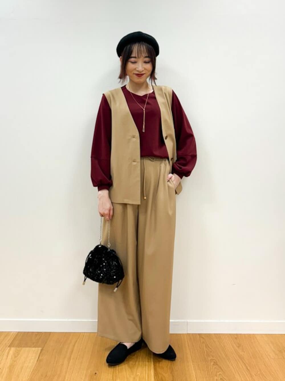ベージュ系のベスト、レッド系のシャツ/ブラウス、ベージュ系のその他パンツを着用したレディースの秋コーディネートの1枚目の写真