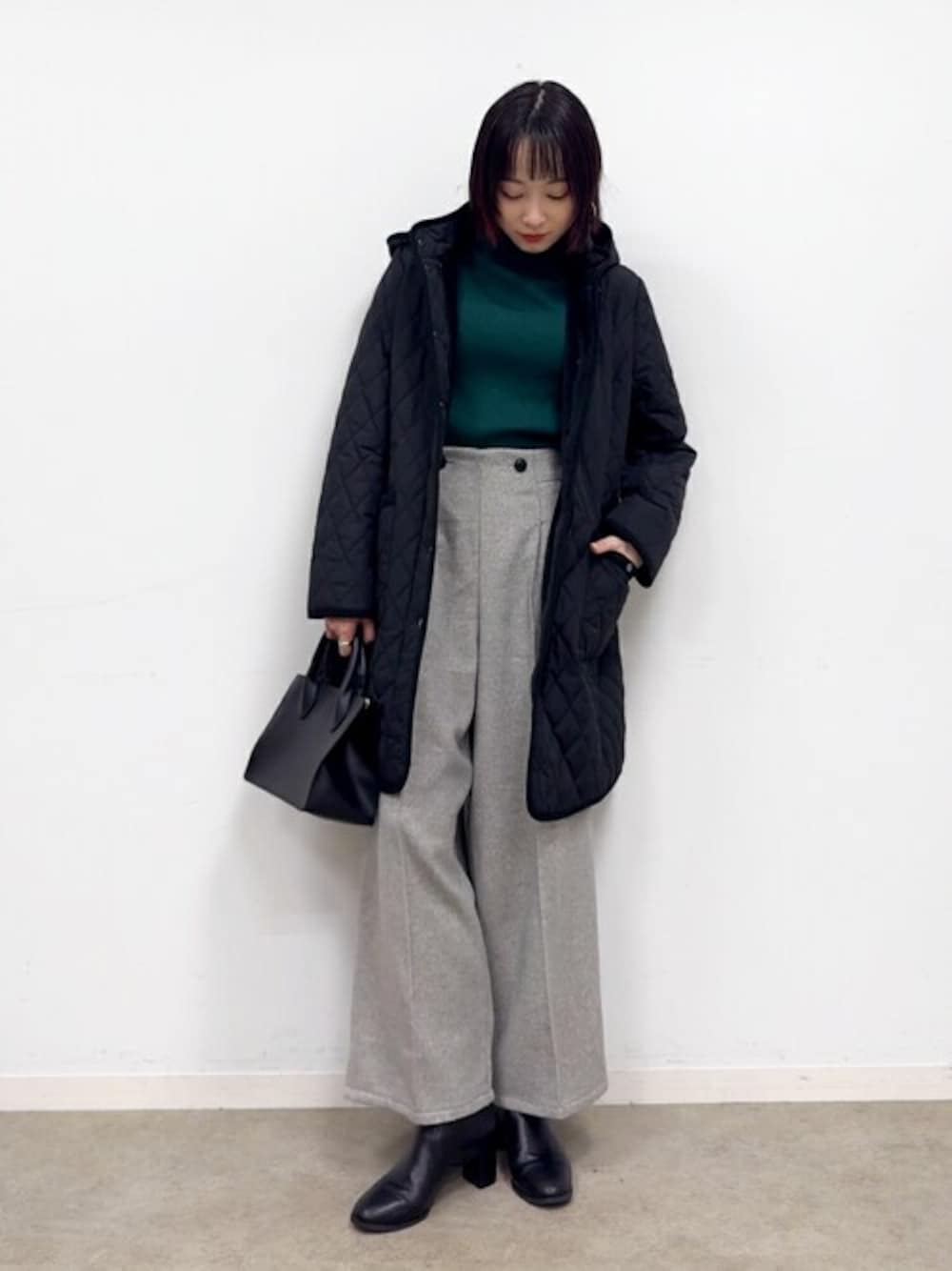 ブラック系のその他アウター、グリーン系のニット/セーター、グレー系のその他パンツを着用したレディースの冬コーディネートの1枚目の写真