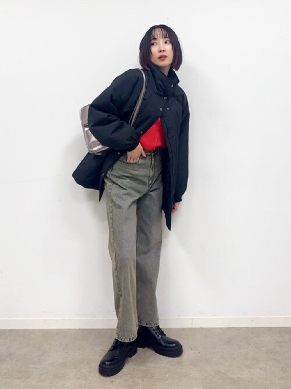 ブラック系のブルゾン、オレンジ系のニット/セーター、ブラック系のブーツを着用したレディースの冬コーディネートの1枚目の写真