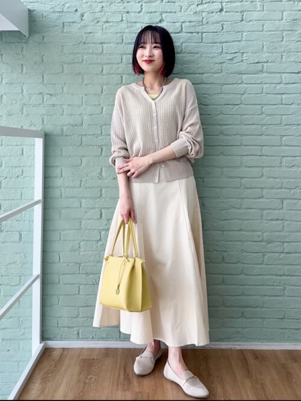 ベージュ系のカーディガン/ボレロ、ホワイト系のスカート、ホワイト系のその他シューズを着用したレディースの春コーディネートの1枚目の写真