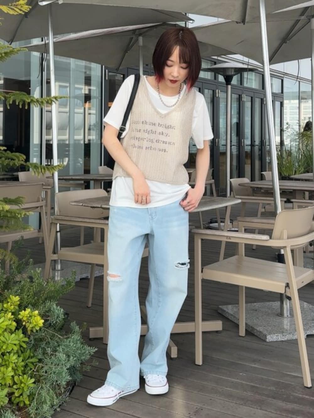 ブルー系のデニムパンツ、ブラック系のショルダーバッグを着用したレディースの春コーディネートの1枚目の写真