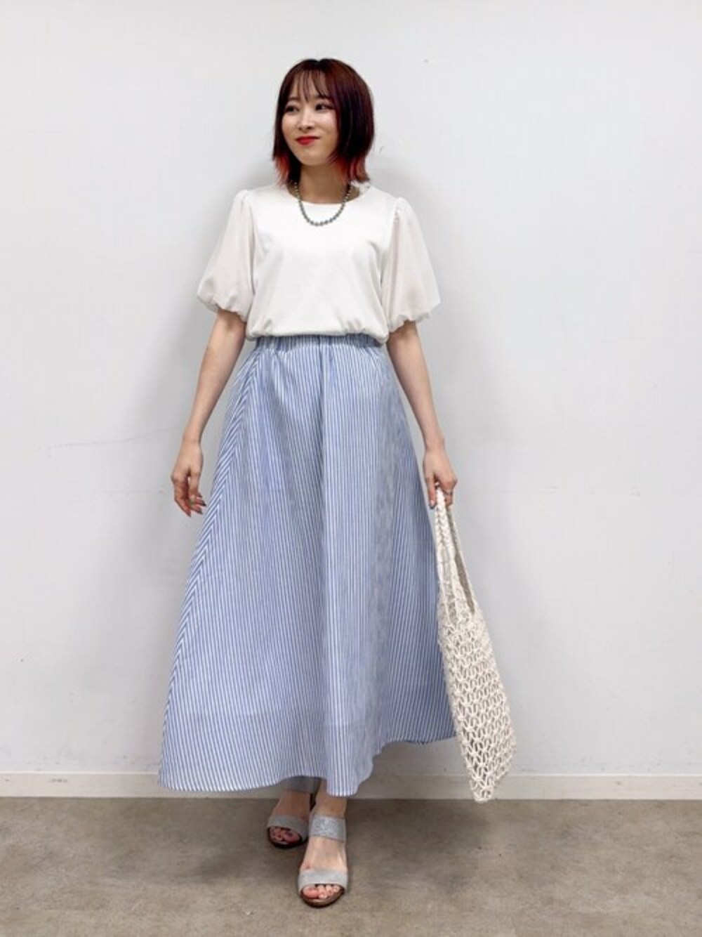 ホワイト系のTシャツ/カットソー、ブルー系のスカート、シルバー系のサンダルを着用したレディースの夏コーディネートの1枚目の写真