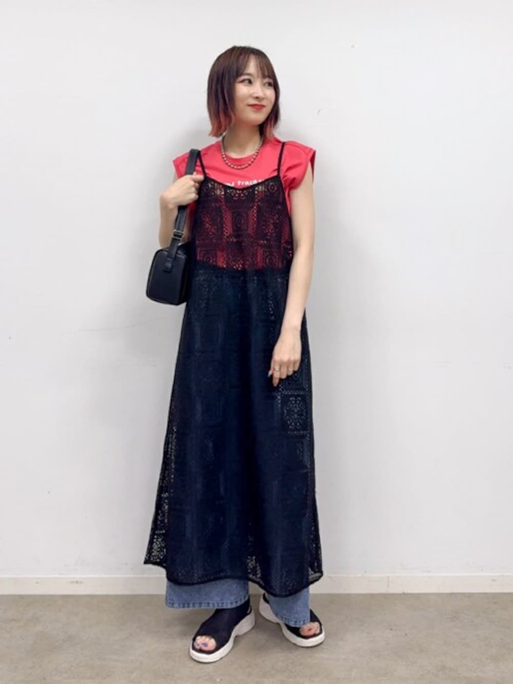 ブラック系のワンピース、ピンク系のTシャツ/カットソー、ブルー系のデニムパンツを着用したレディースの夏コーディネートの1枚目の写真