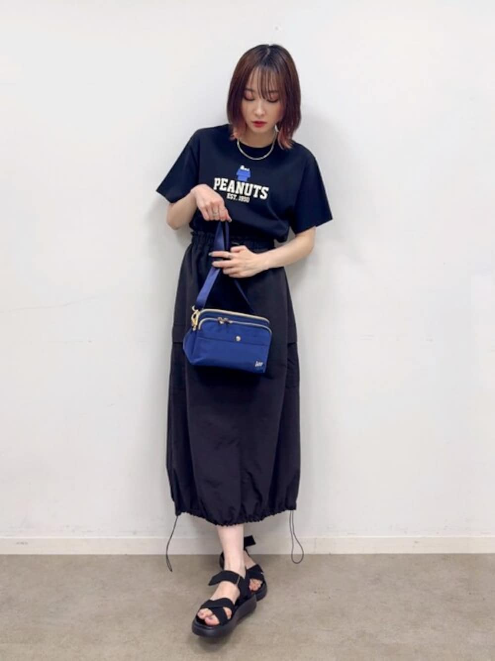 ブラック系のTシャツ/カットソー、ブラック系のスカート、ブラック系のサンダルを着用したレディースの夏コーディネートの1枚目の写真