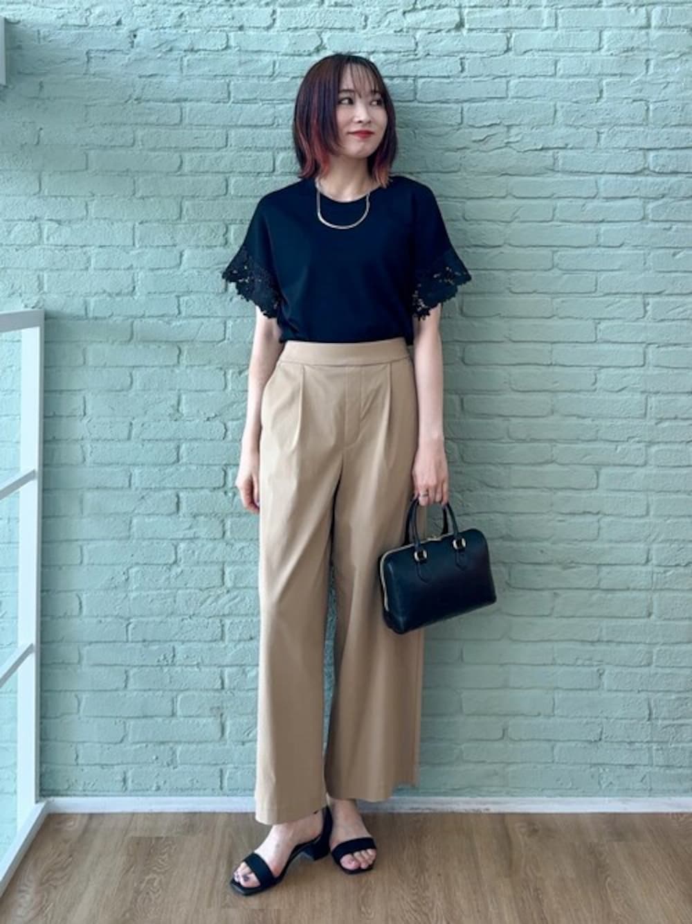 ブラック系のニット/セーター、ベージュ系のその他パンツ、ブラック系のサンダルを着用したレディースの夏コーディネートの1枚目の写真