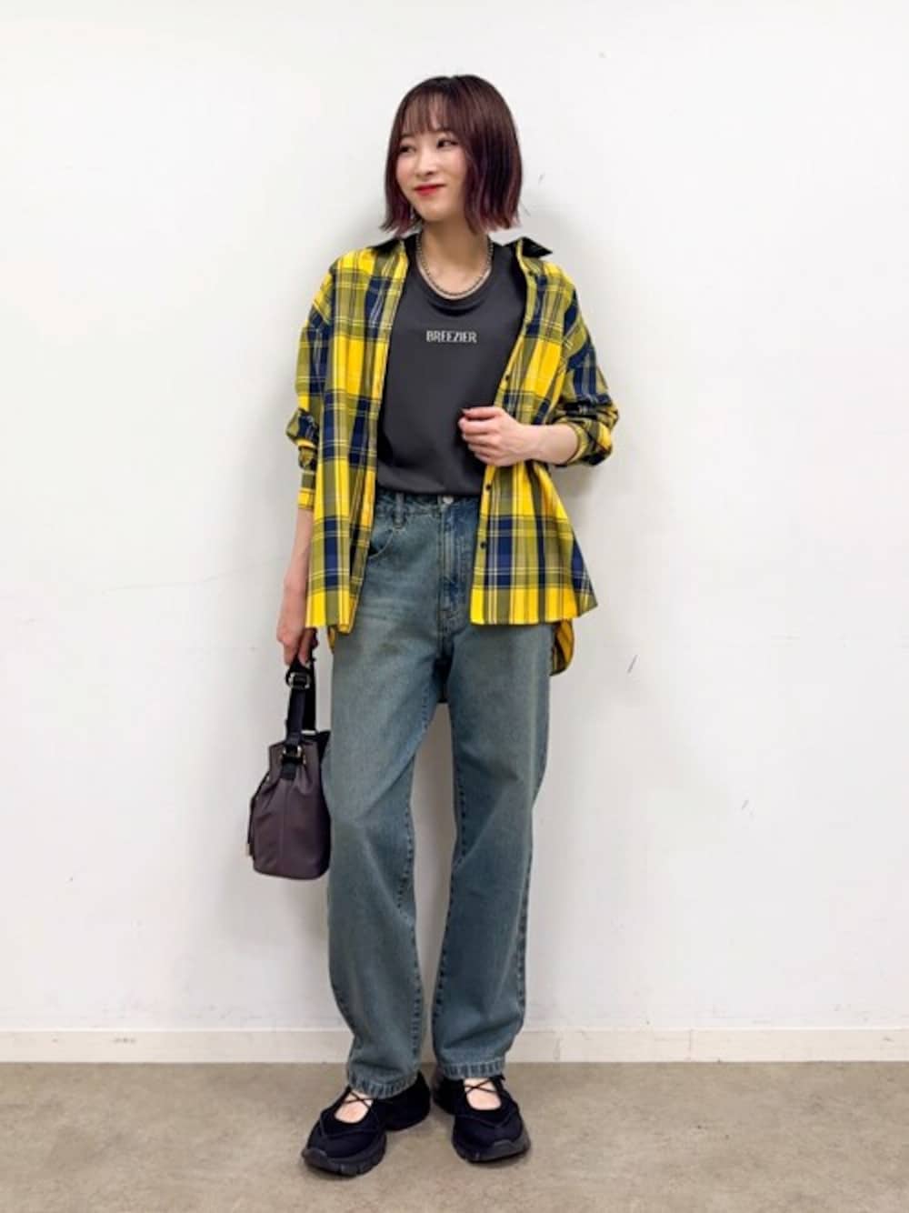 イエロー系のシャツ/ブラウス、グレー系のTシャツ/カットソー、ブラック系のスニーカーを着用したレディースの秋コーディネートの1枚目の写真