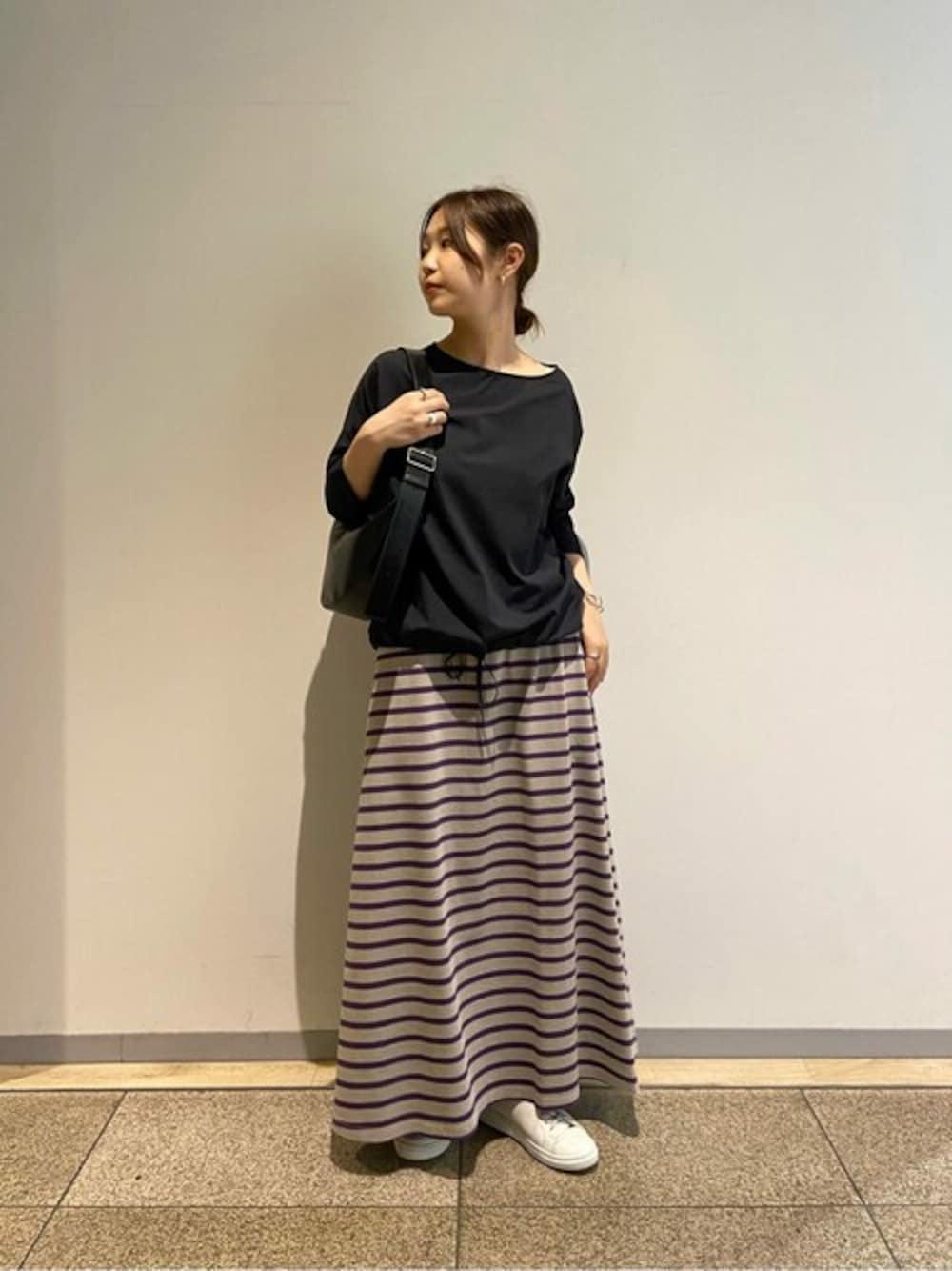 ブラウン系のスカート、ブラック系のシャツ/ブラウス、ホワイト系のスニーカーを着用したレディースの夏コーディネートの1枚目の写真