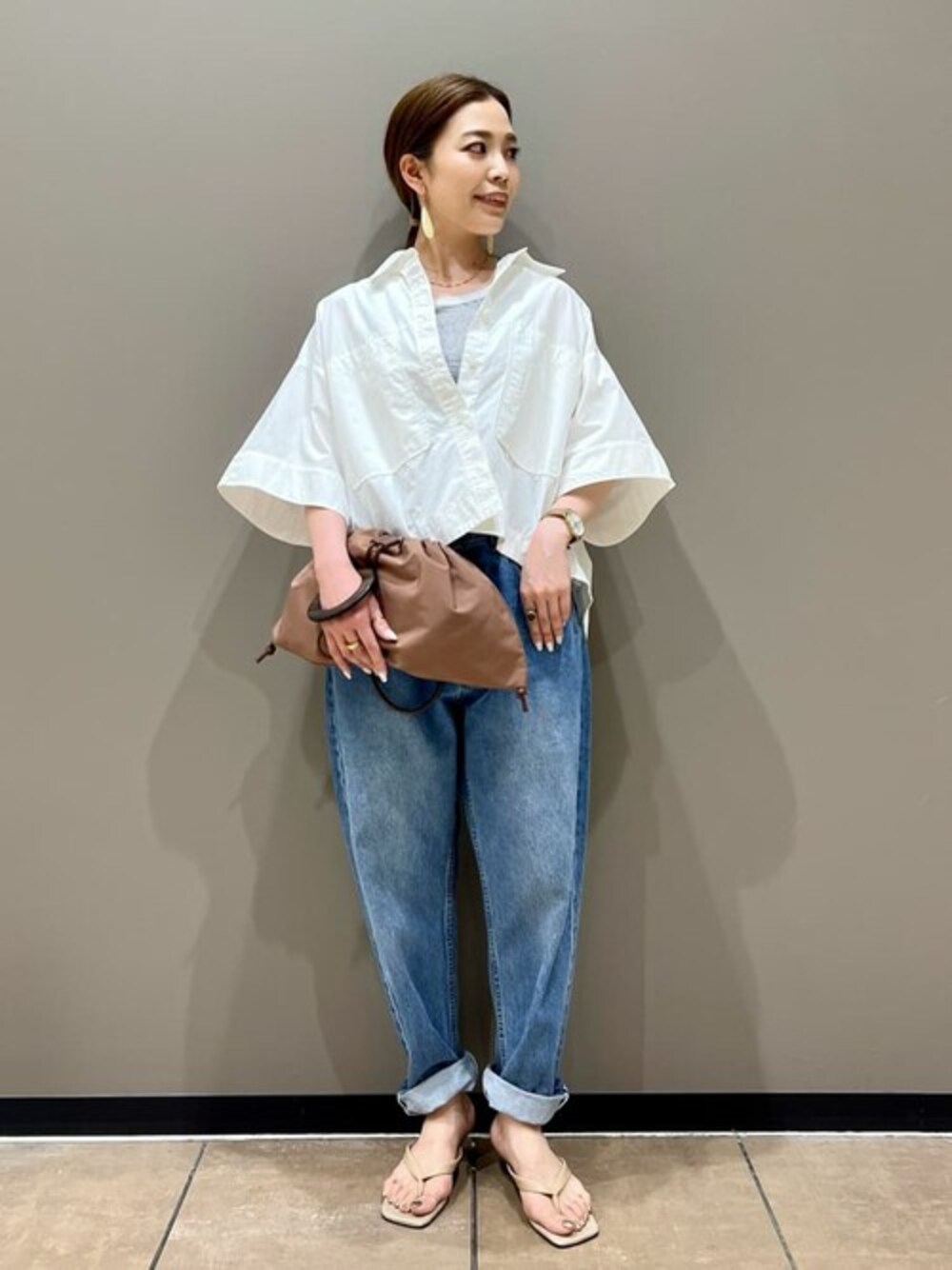 ホワイト系のシャツ/ブラウス、ホワイト系のショルダーバッグ、ベージュ系のサンダルを着用したレディースの夏コーディネートの1枚目の写真
