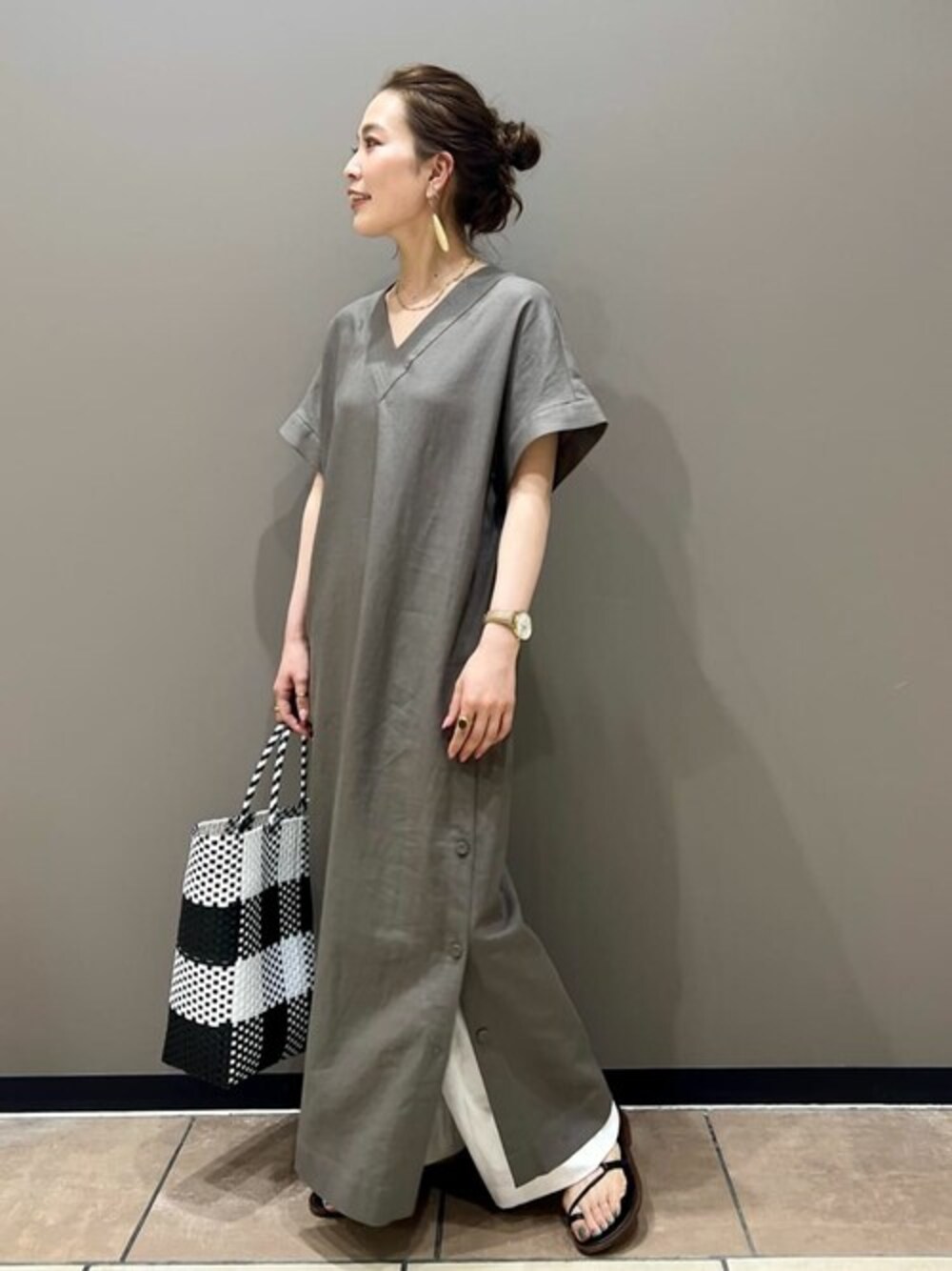 グリーン系のワンピース、ホワイト系のスラックス、ホワイト系のトートバッグを着用したレディースの夏コーディネートの1枚目の写真