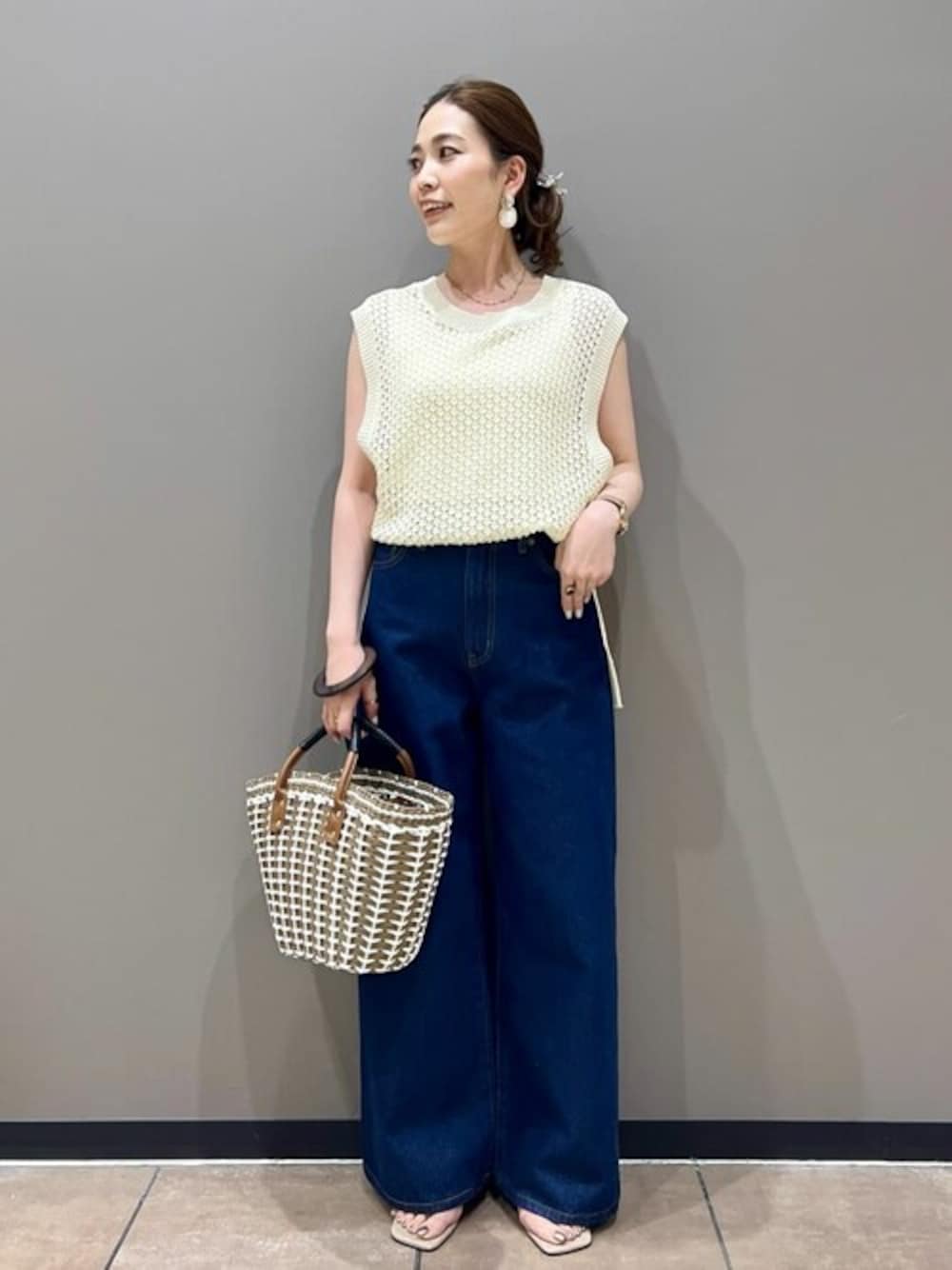 ホワイト系のニット/セーター、ブルー系のデニムパンツ、ベージュ系のサンダルを着用したレディースの夏コーディネートの1枚目の写真