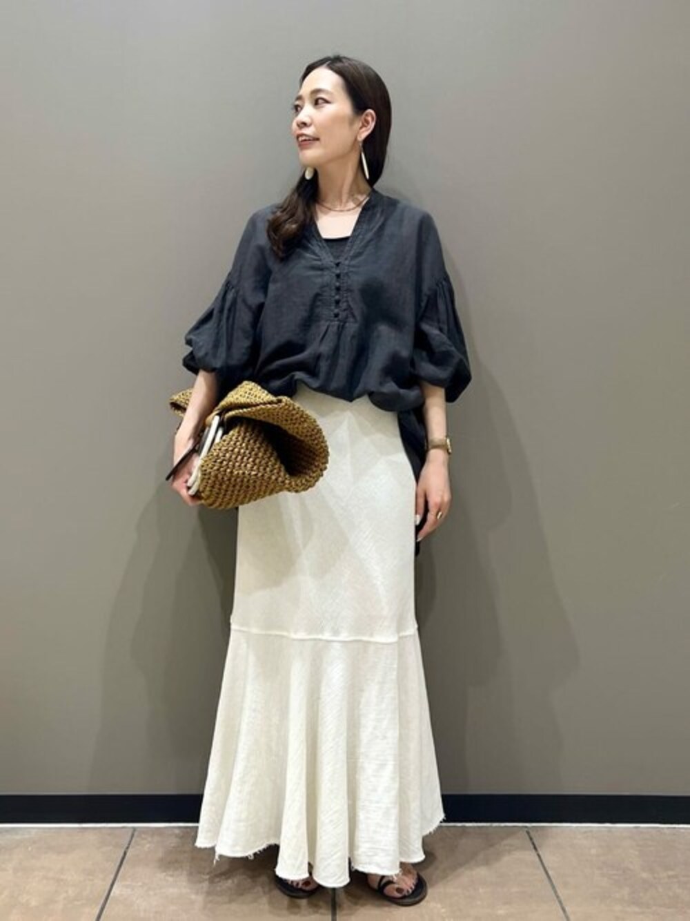 ブラック系のシャツ/ブラウス、ベージュ系のかごバッグを着用したレディースの夏コーディネートの1枚目の写真