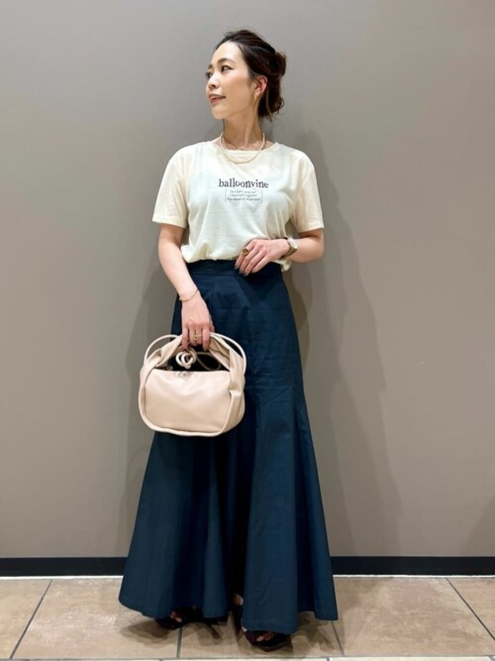 ブラック系のスカート、ホワイト系のTシャツ/カットソー、ピンク系のショルダーバッグを着用したレディースの夏コーディネートの1枚目の写真