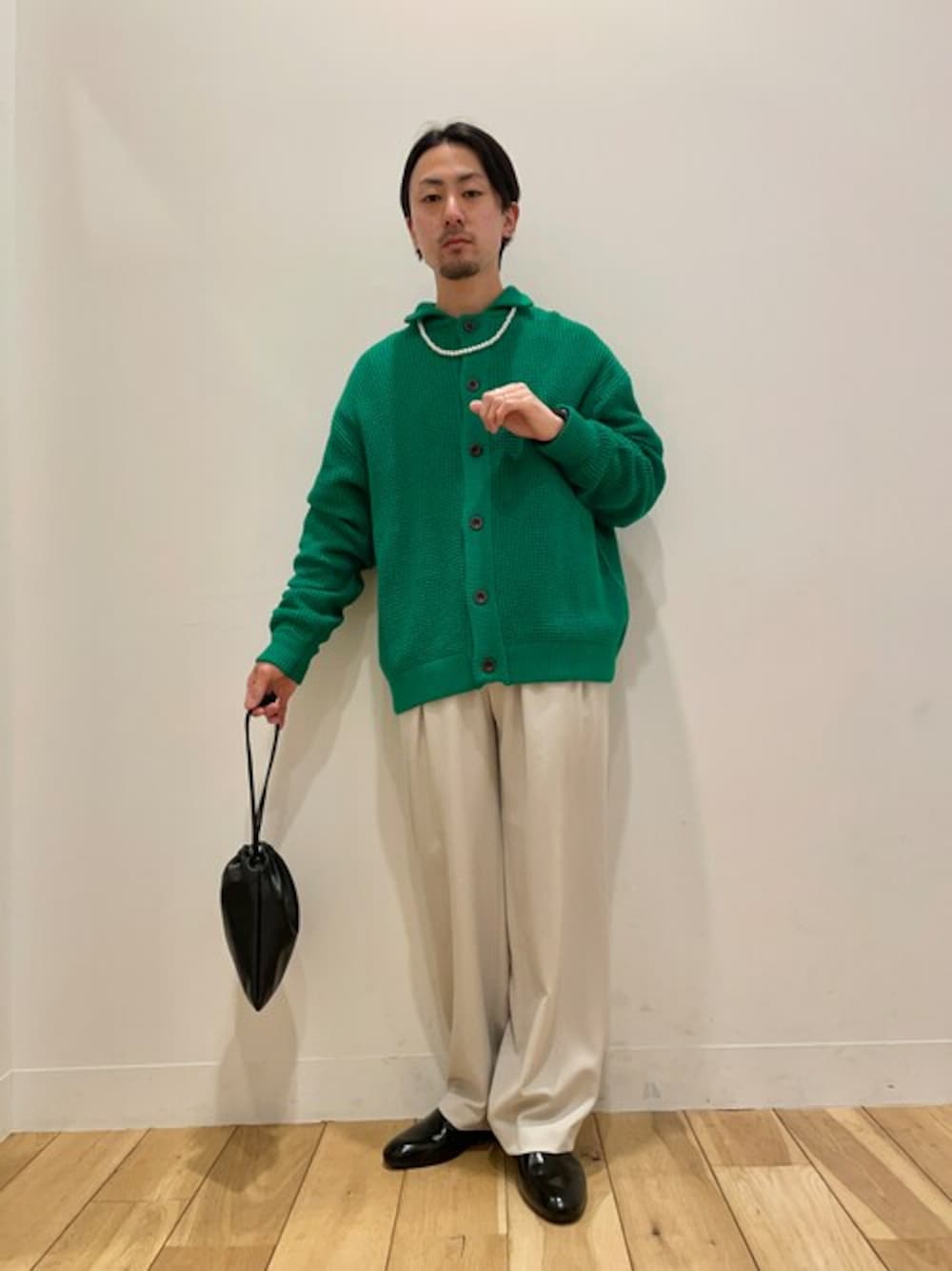 グリーン系のカーディガン/ボレロ、ベージュ系のスラックスを着用したメンズの冬コーディネートの1枚目の写真