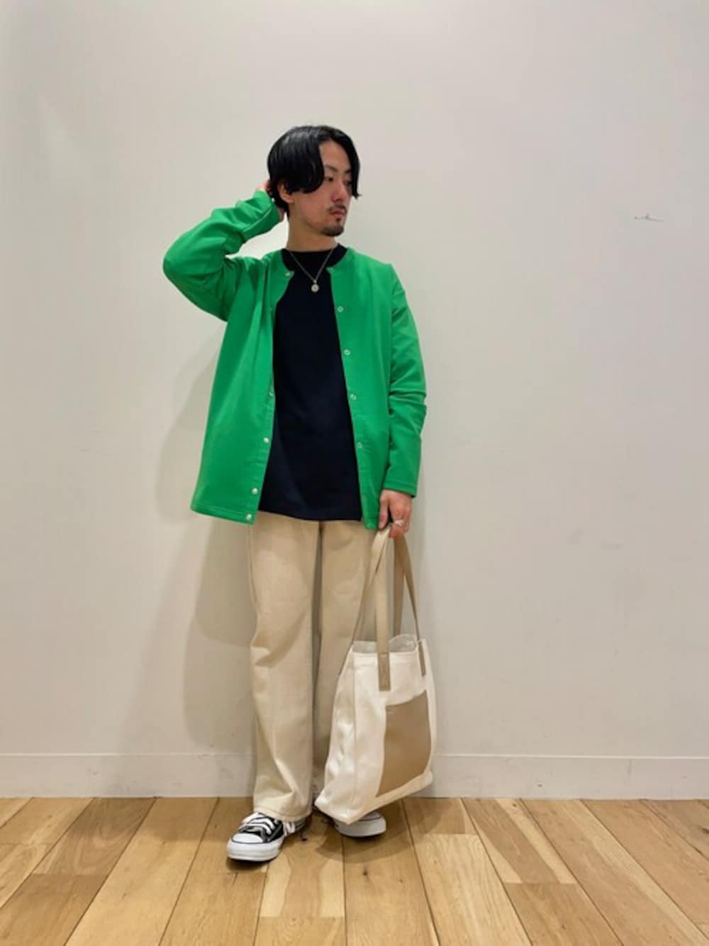 グリーン系のカーディガン/ボレロ、ホワイト系のトートバッグ、ブラック系のTシャツ/カットソーを着用したメンズの春コーディネートの1枚目の写真