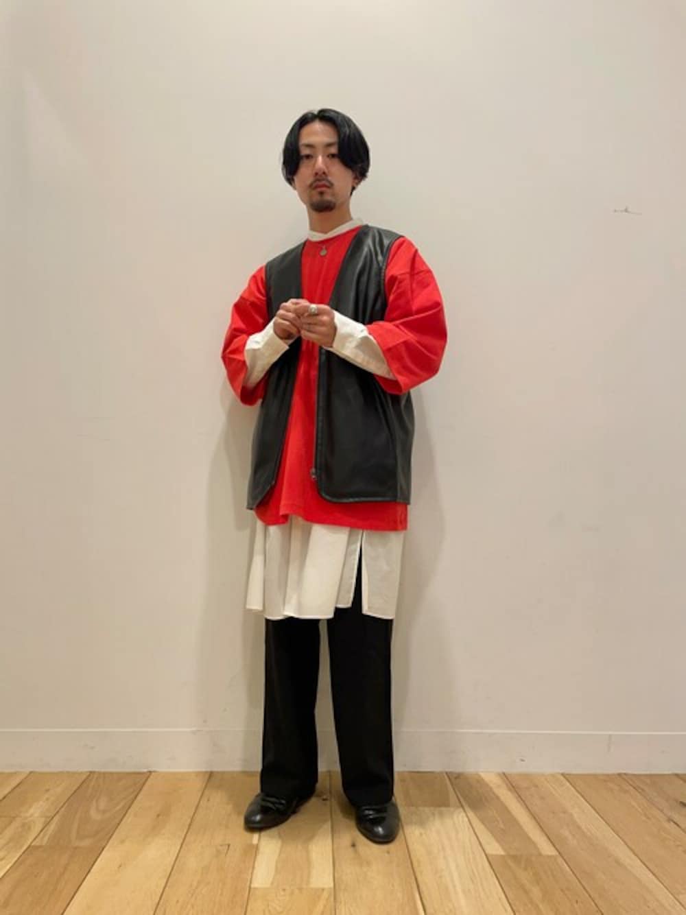 オレンジ系のTシャツ/カットソー、ホワイト系のシャツ/ブラウス、ブラック系のスラックスを着用したメンズの春コーディネートの1枚目の写真