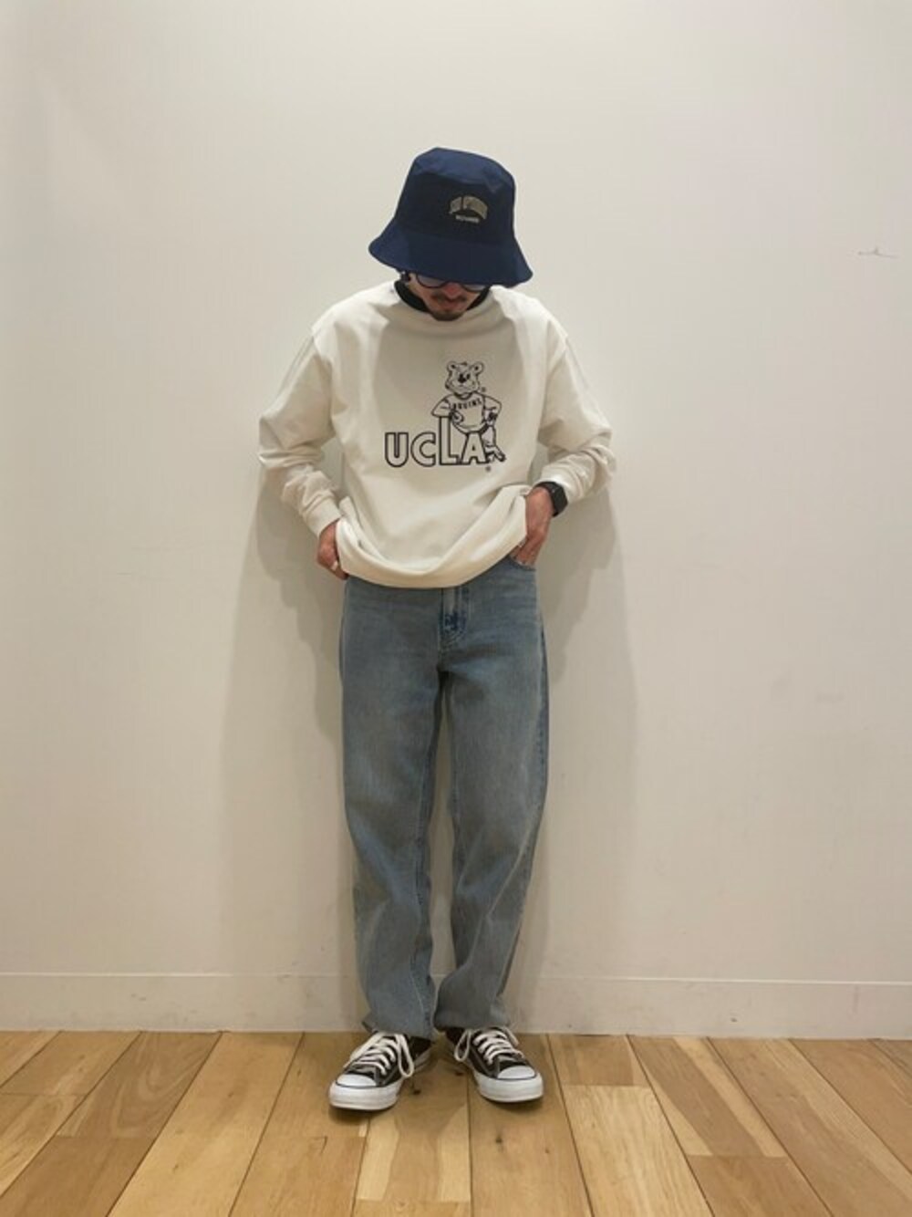 ホワイト系のTシャツ/カットソー、ブルー系のデニムパンツ、ブルー系のハットを着用したメンズの春コーディネートの1枚目の写真