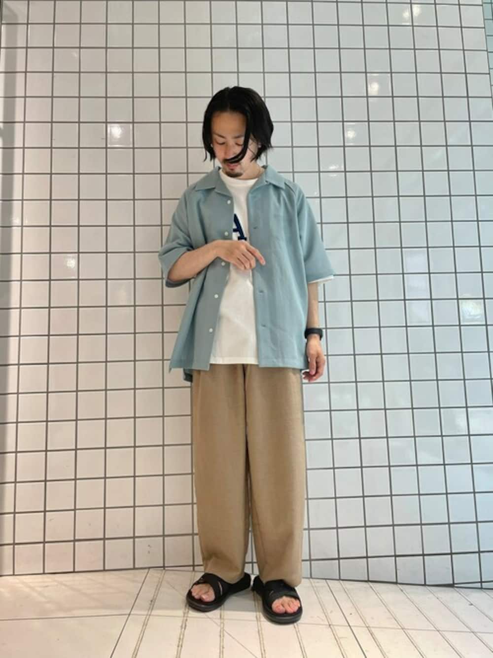 グリーン系のシャツ/ブラウス、ベージュ系のスラックス、ホワイト系のTシャツ/カットソーを着用したメンズの春コーディネートの1枚目の写真