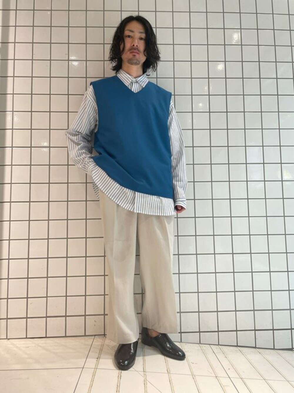 ホワイト系のシャツ/ブラウス、ブルー系のベスト、ベージュ系のスラックスを着用したメンズの秋コーディネートの1枚目の写真