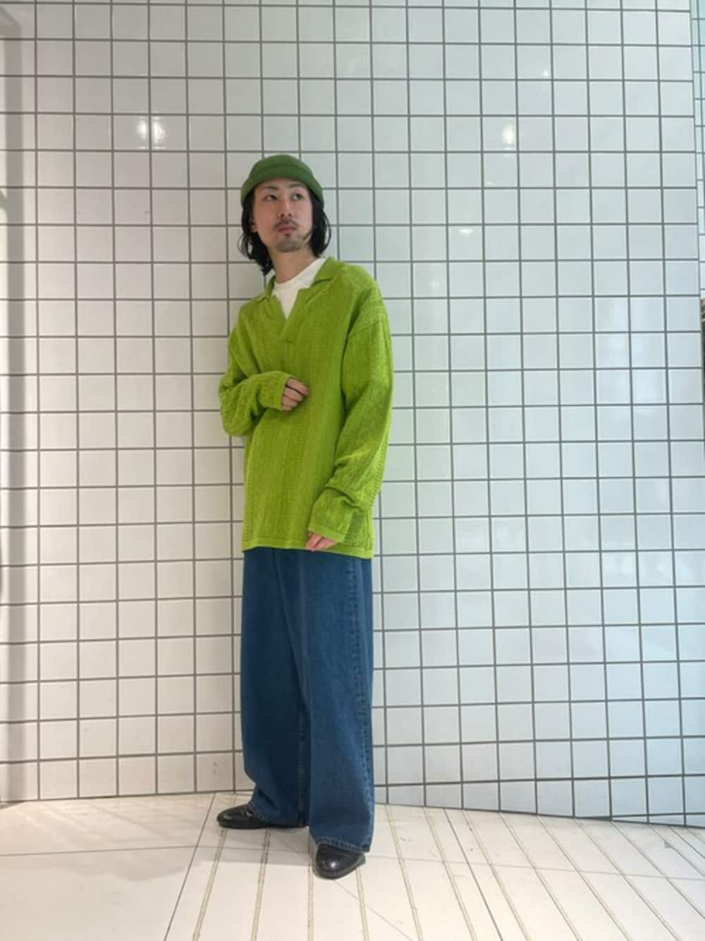グリーン系のポロシャツ、ブルー系のデニムパンツを着用したメンズの秋コーディネートの1枚目の写真