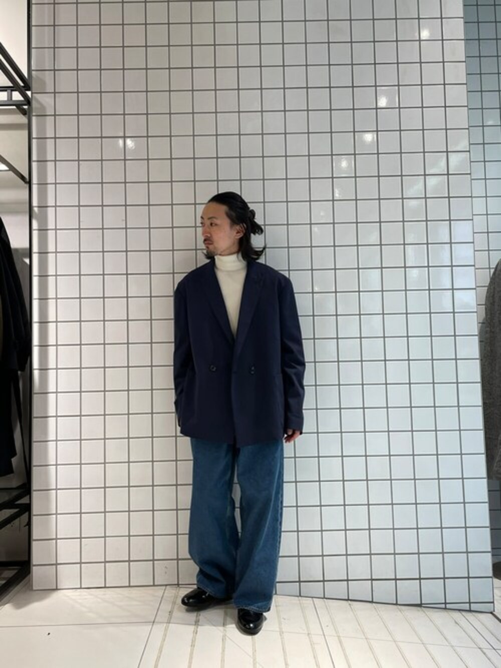 ブルー系のテーラードジャケット、ブルー系のデニムパンツ、ホワイト系のニット/セーターを着用したメンズの冬コーディネートの1枚目の写真