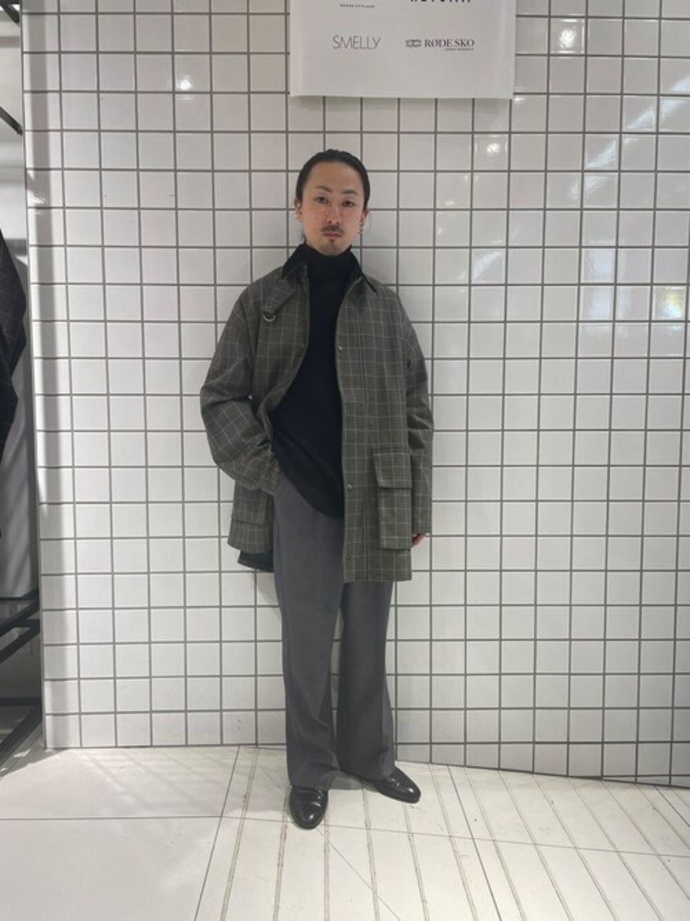 グリーン系のミリタリージャケット、ブラック系のニット/セーター、グレー系のスラックスを着用したメンズの冬コーディネートの1枚目の写真