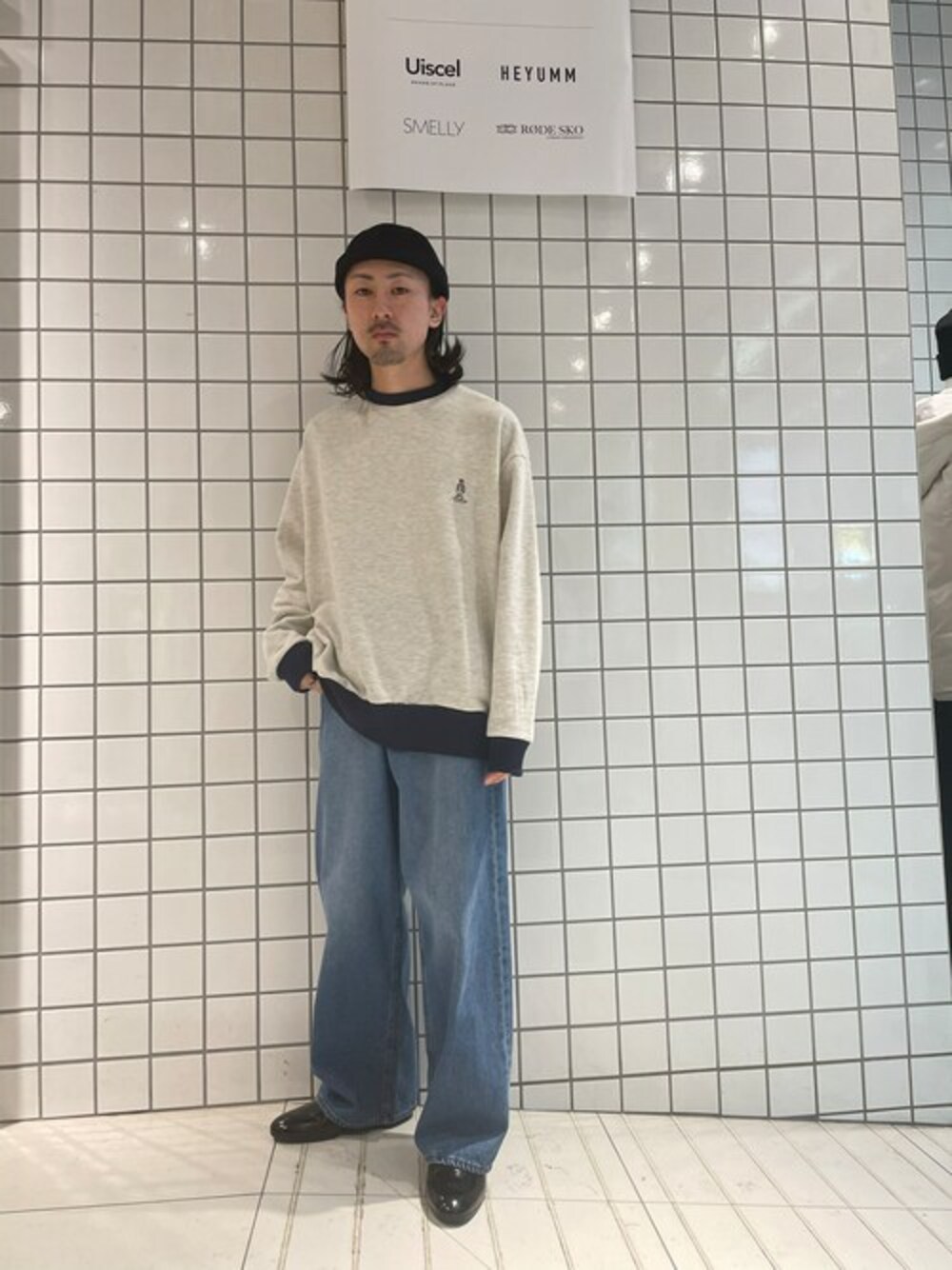 ベージュ系のスウェット、ブルー系のデニムパンツを着用したメンズの冬コーディネートの1枚目の写真