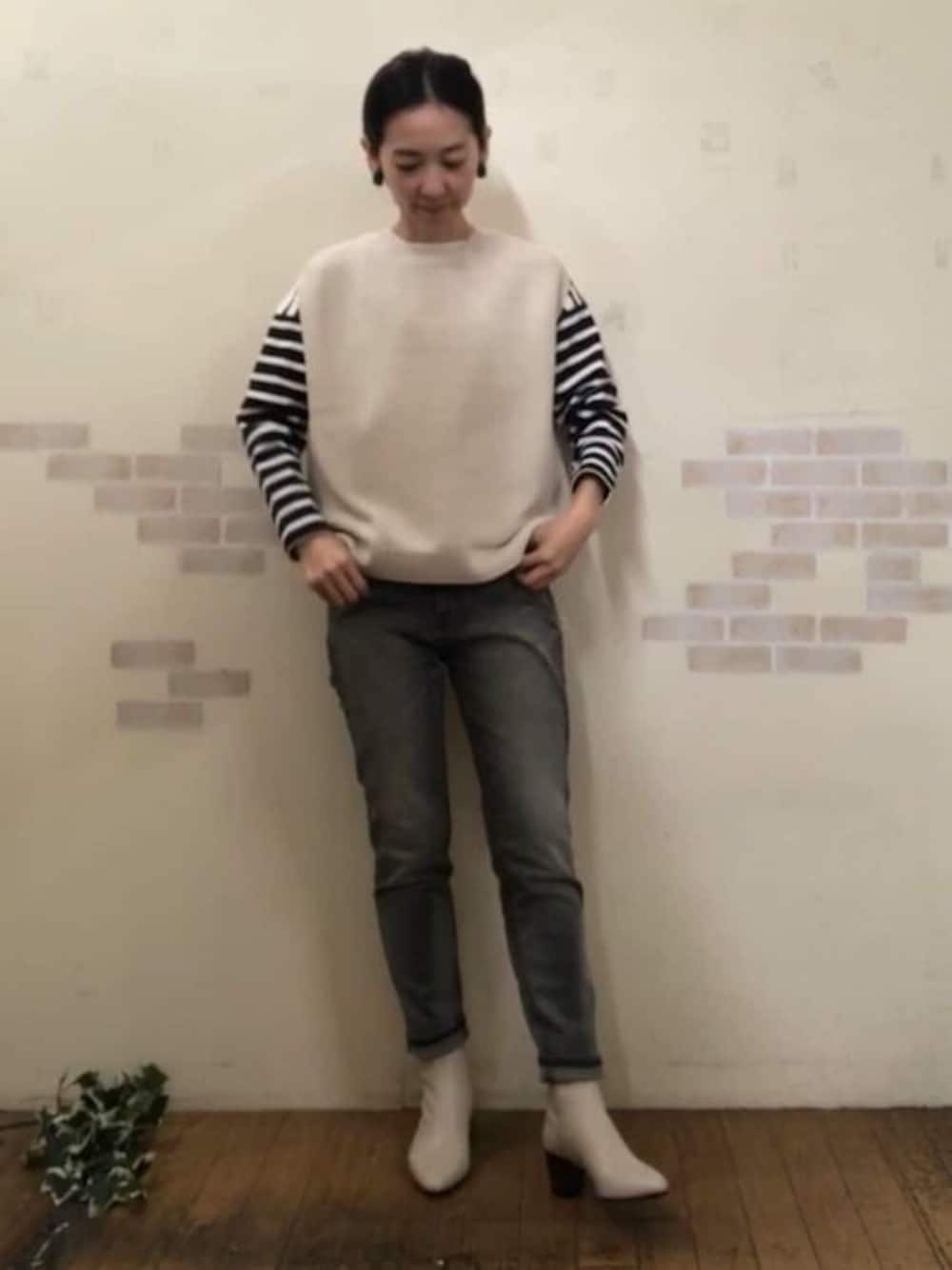 ホワイト系のベスト、ブルー系のTシャツ/カットソー、ブラック系のデニムパンツを着用したレディースの冬コーディネートの1枚目の写真