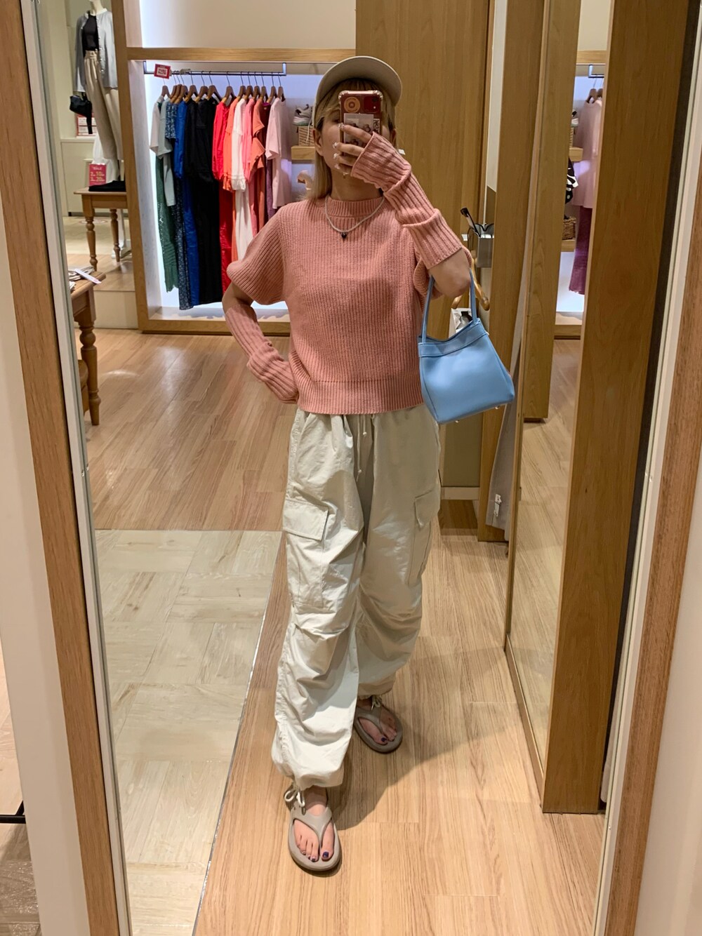 ピンク系のニット/セーター、ホワイト系のカーゴパンツを着用したレディースの夏コーディネートの1枚目の写真