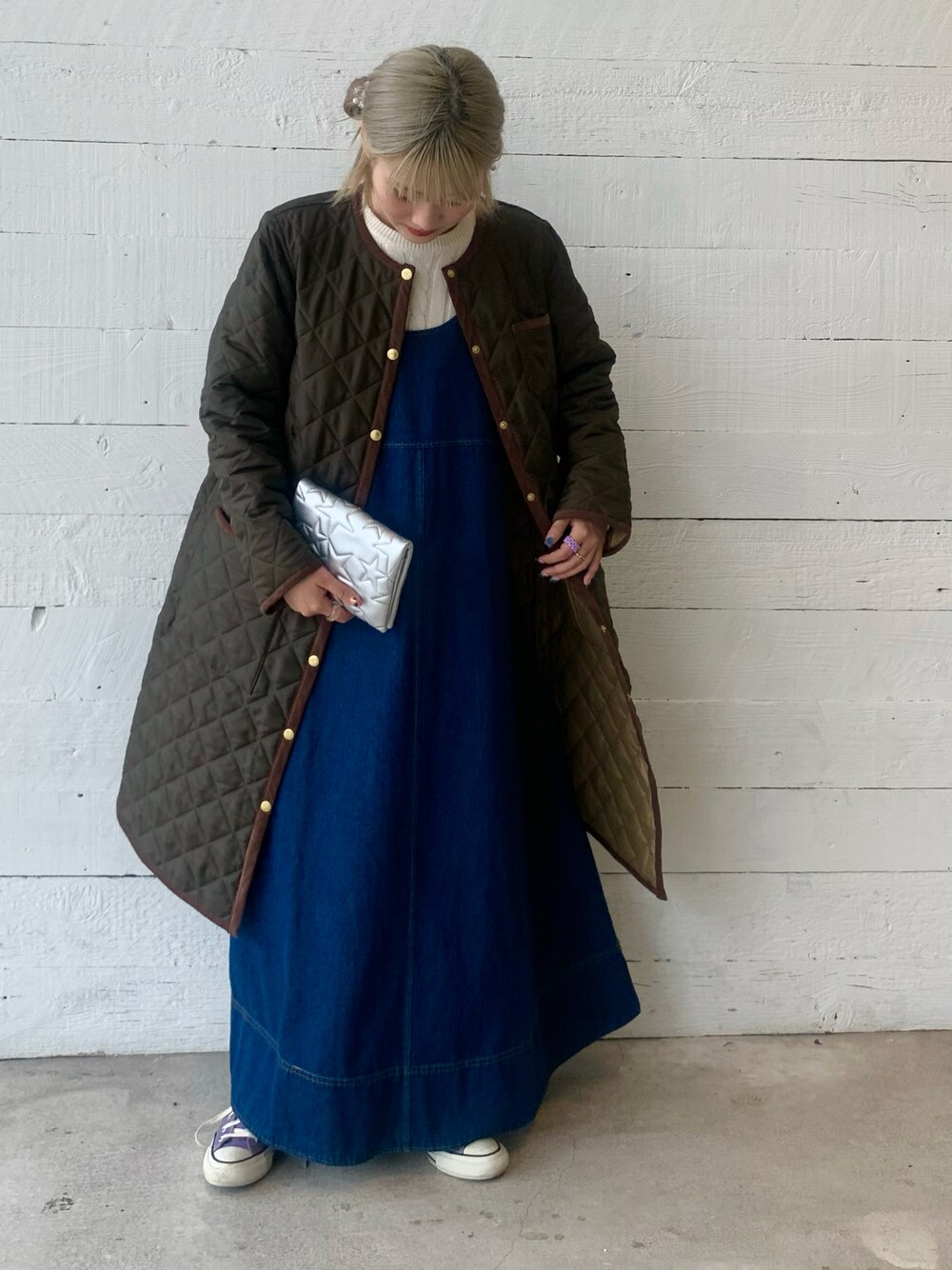 ブラック系のジャンパースカート、ホワイト系のニット/セーターを着用したレディースの秋コーディネートの1枚目の写真