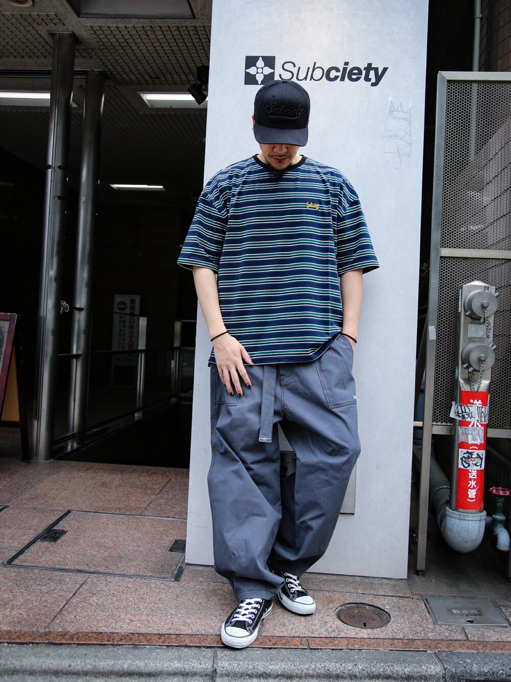ブルー系のTシャツ/カットソー、グレー系のその他パンツ、ブラック系のスニーカーを着用したメンズの春コーディネートの1枚目の写真