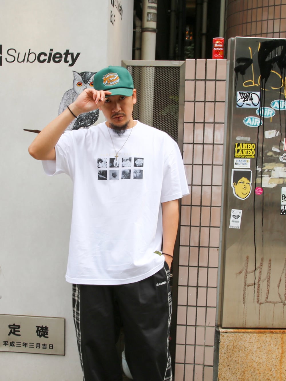 ホワイト系のTシャツ/カットソー、ブラック系のその他パンツ、グリーン系のキャップを着用したメンズの春コーディネートの1枚目の写真