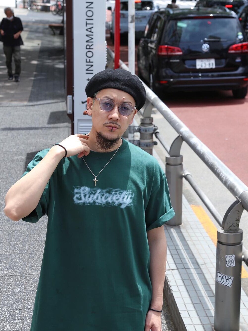 グリーン系のTシャツ/カットソー、ブラック系のハンチング/ベレー帽、ブルー系のサングラスを着用したメンズの夏コーディネートの1枚目の写真