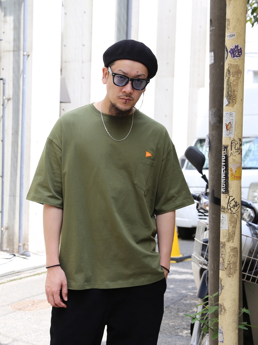 グリーン系のTシャツ/カットソー、ブラック系のその他パンツ、ブラック系のハンチング/ベレー帽を着用したメンズの春コーディネートの1枚目の写真