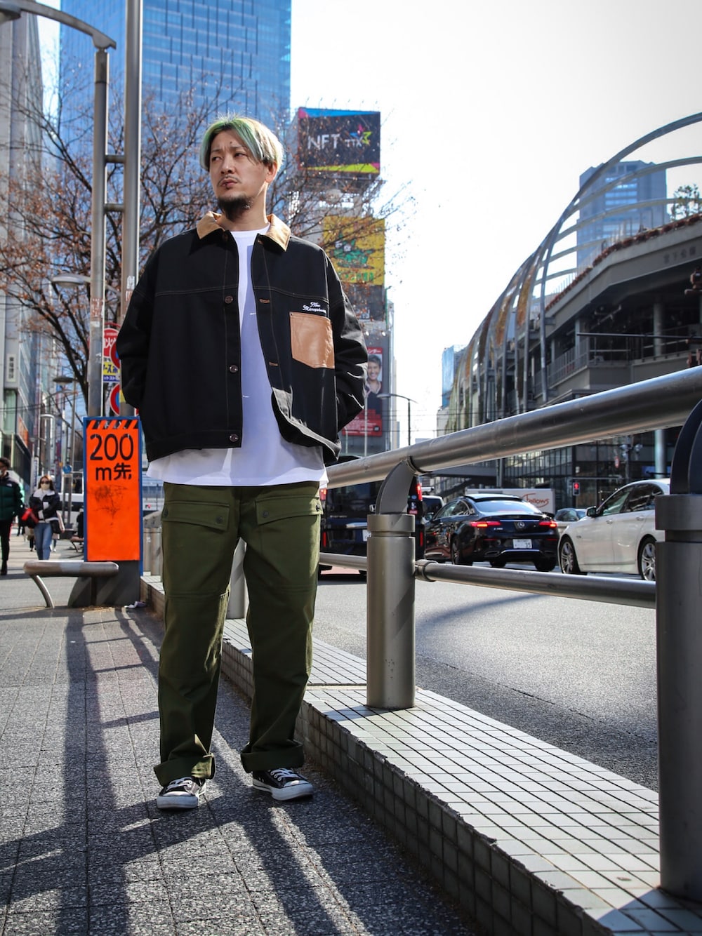 ブラック系のブルゾン、グリーン系のカーゴパンツ、ホワイト系のTシャツ/カットソーを着用したメンズの冬コーディネートの1枚目の写真